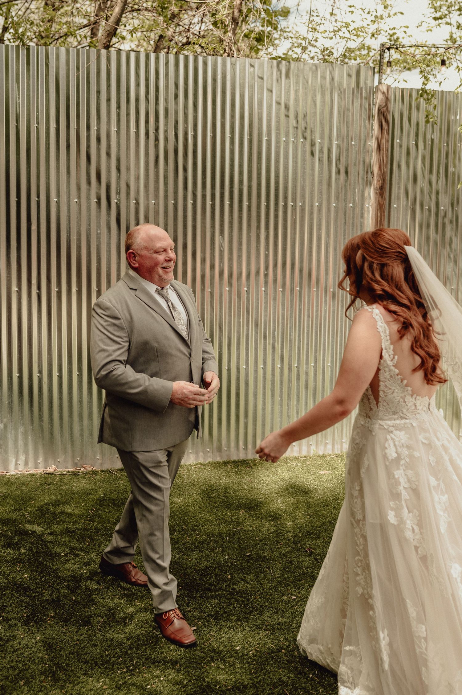 A sequence of photos showing a first look moment between a bride in white lace and groom in gray at an outdoor wedding.