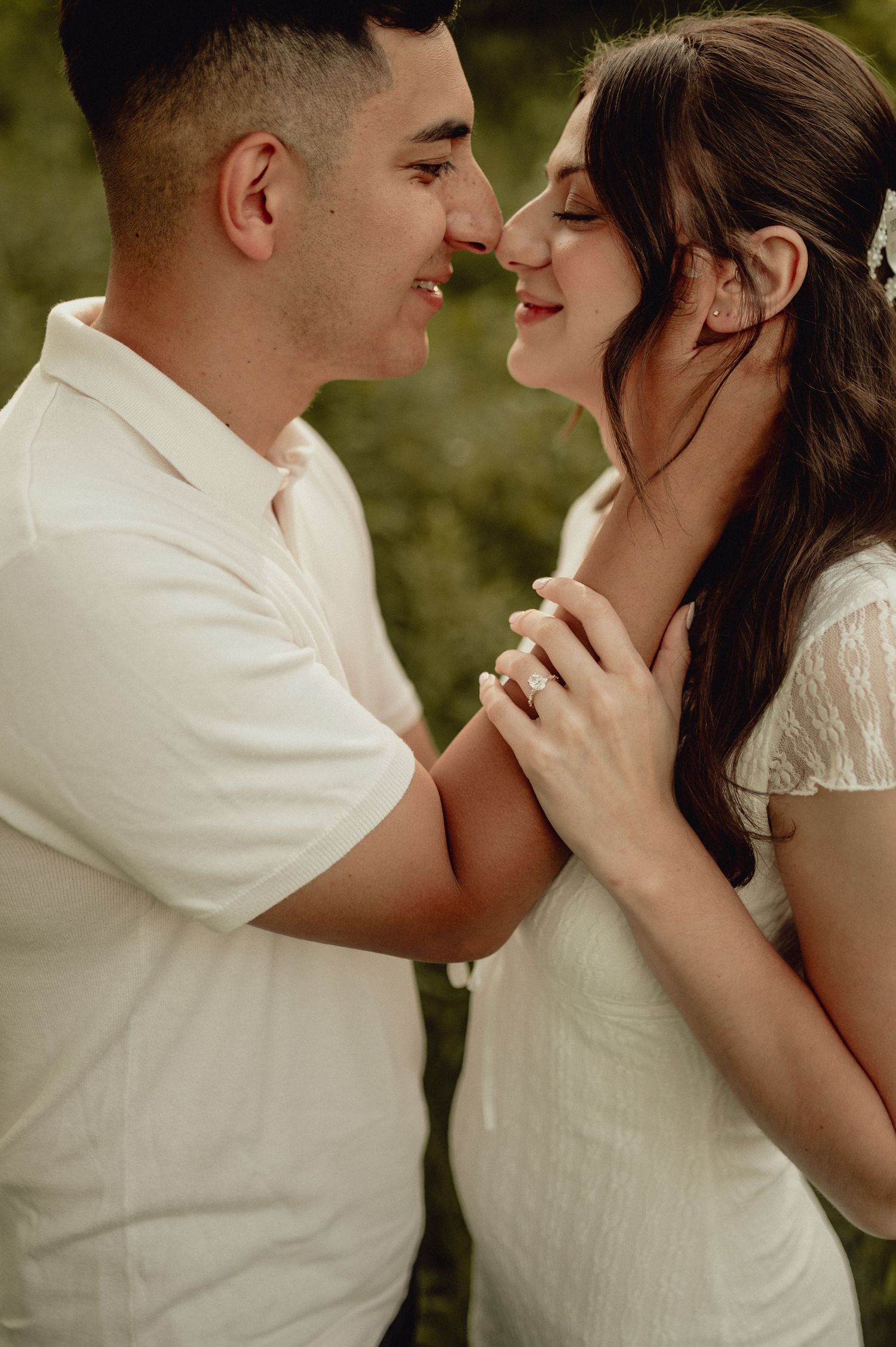 An intimate portrait of a couple sharing a tender moment in a garden setting.