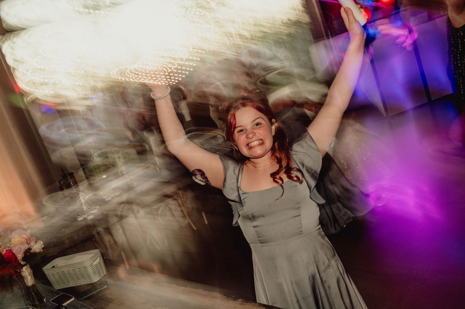Blurred motion photos of people dancing at a party with purple lighting and atmospheric effects.
