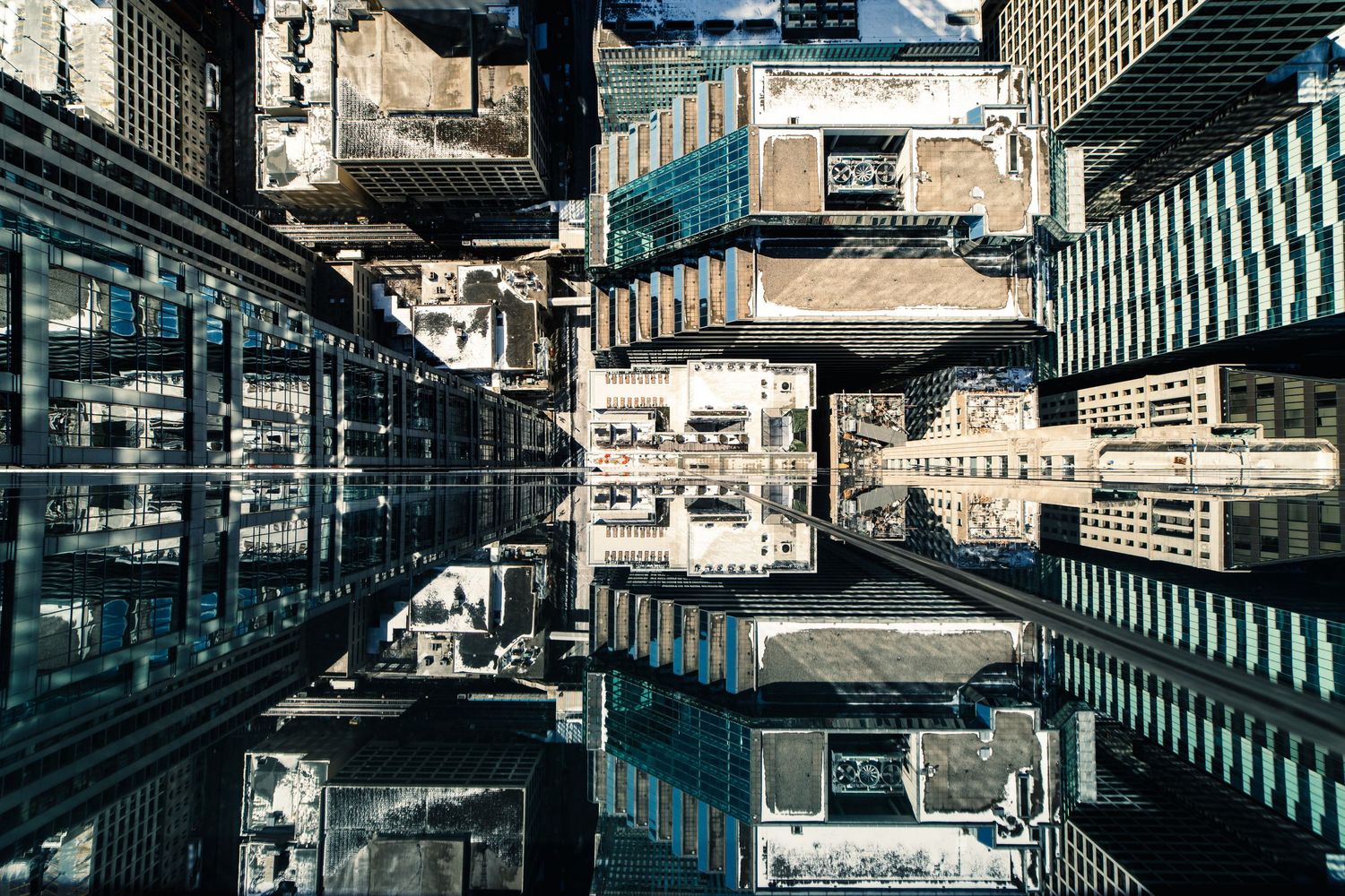 Modern urban architecture creates geometric patterns with glass and steel reflections.