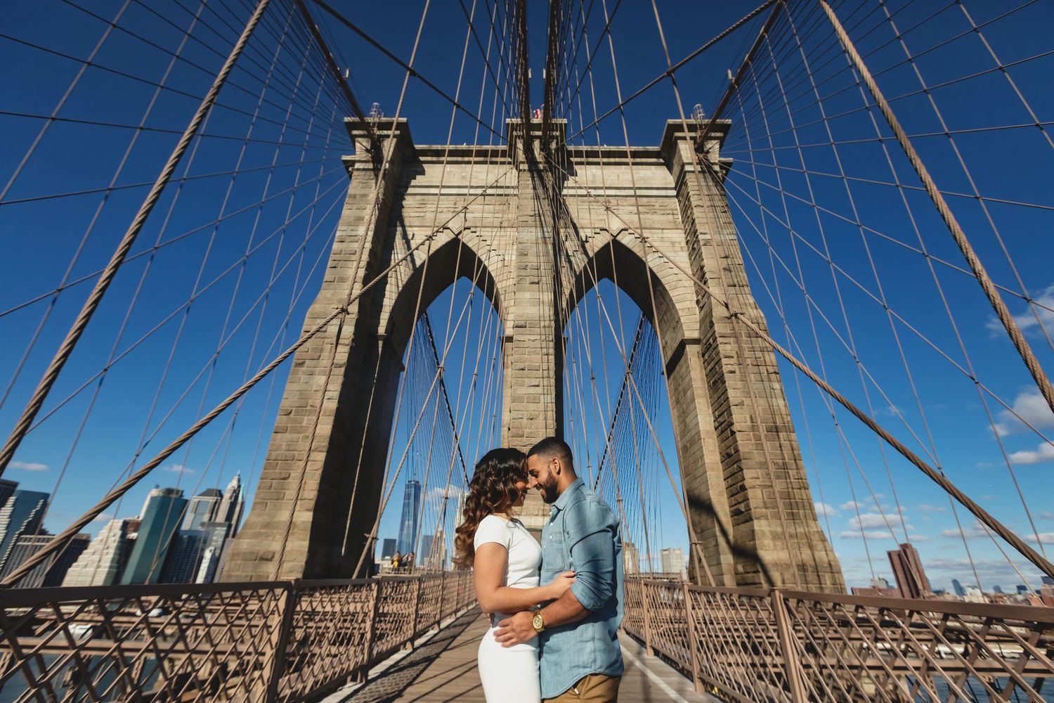 Wedding photo shoot on the iconic Brooklyn Bridge with dramatic architecture.