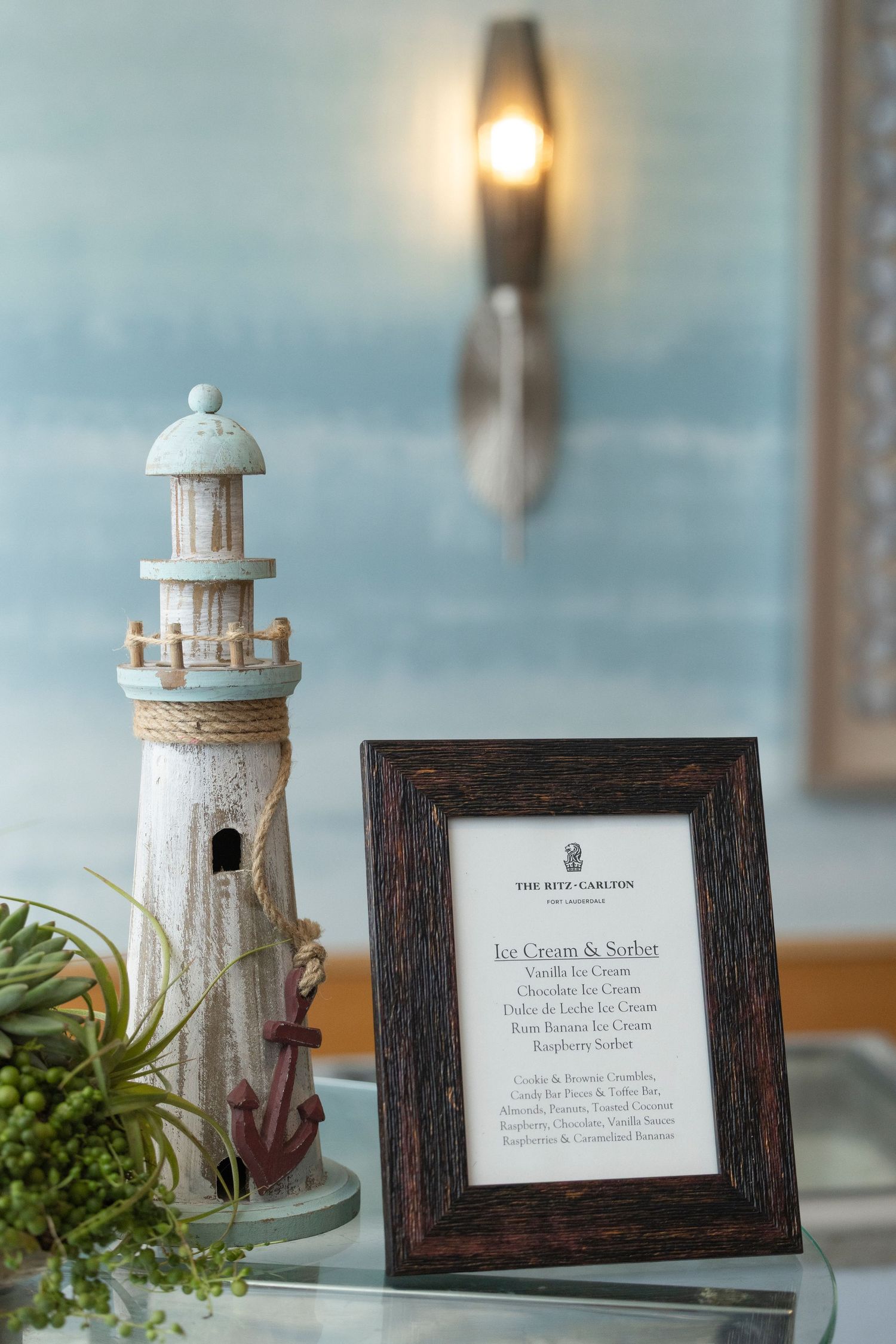 Decorative lighthouse centerpieces and framed cards displayed on a table with coastal-themed decor.
