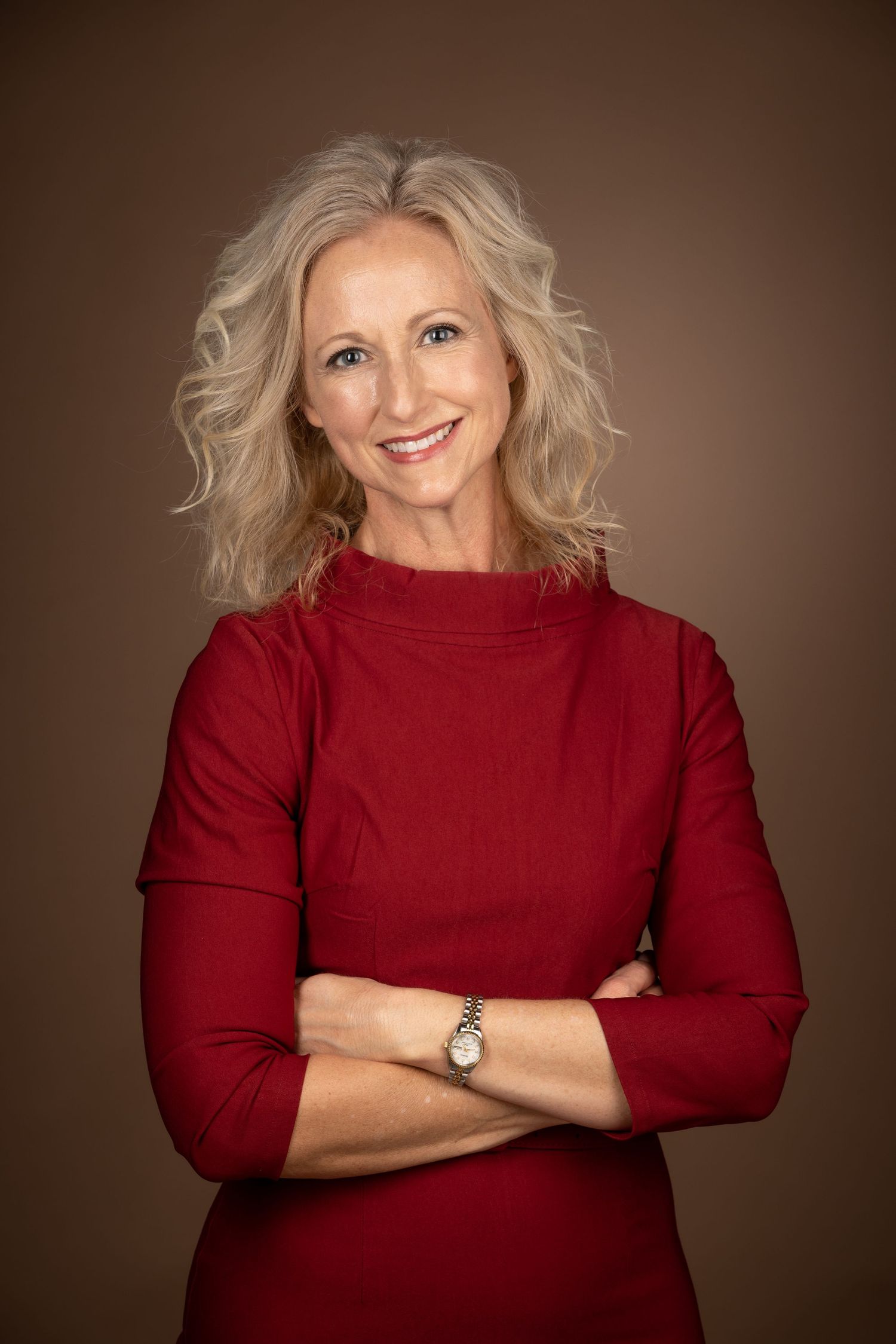 Professional portrait series showing person in deep red sweater against dark brown background posing with various expressions.