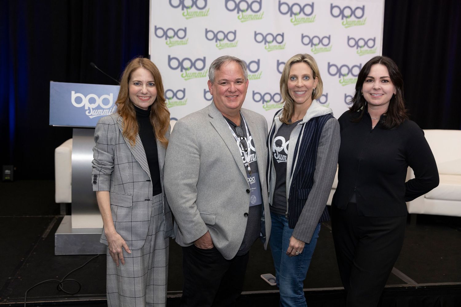 Group of people standing together against a backdrop with repeating 'bpd' logos.