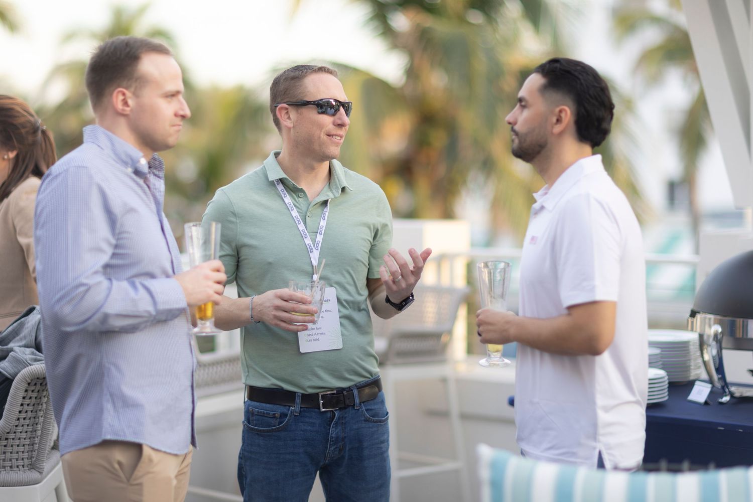 Group of professionals engaged in casual networking conversation at an outdoor business event.
