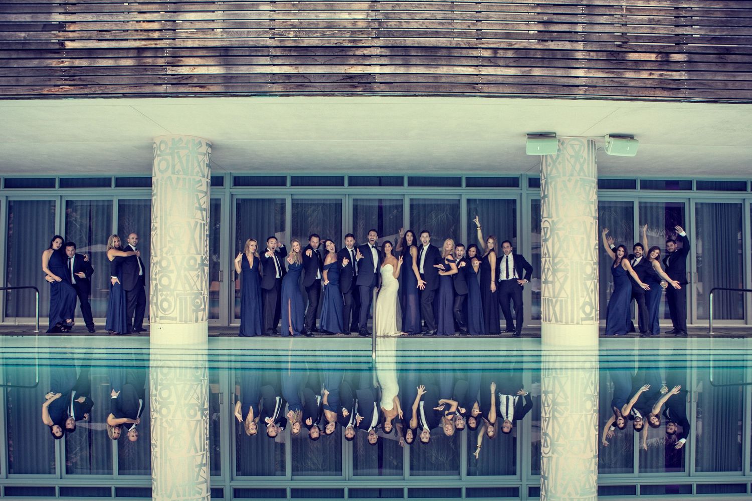 Wedding party poses along modernist architectural balconies for creative group photo.