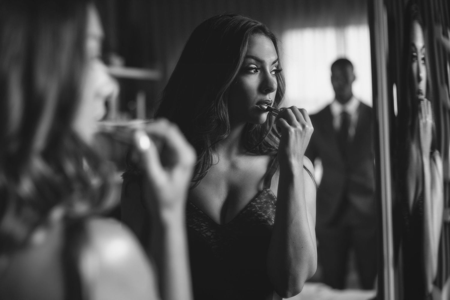 Wedding party reflection captured in mirror with soft focus and dramatic lighting.