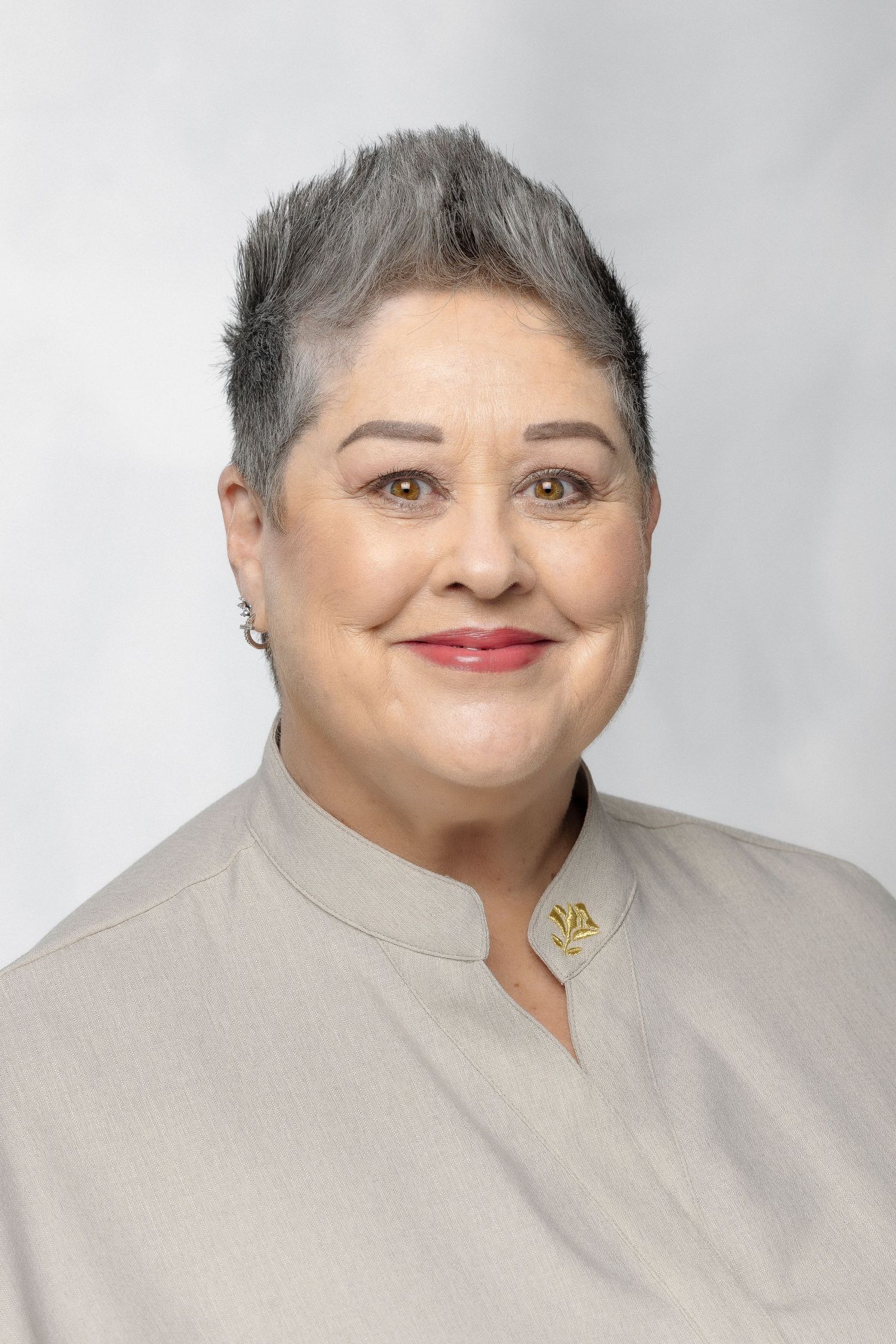 Woman wearing beige clothing smiling in a headshot collage against a light gray background.