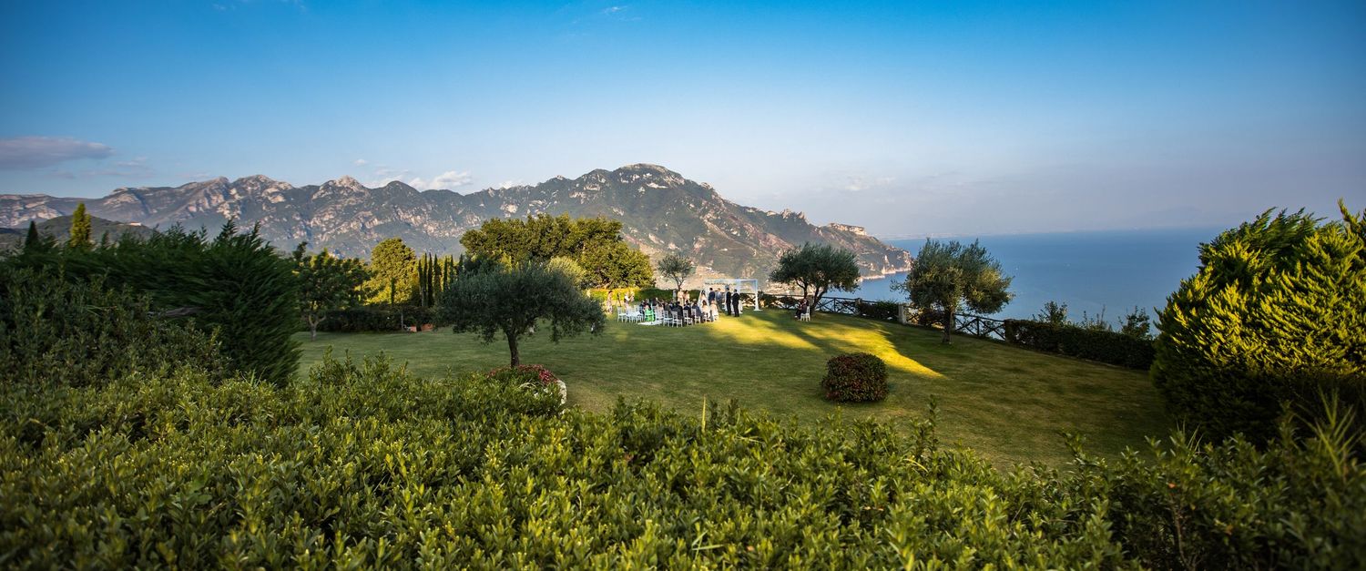 Rolling green hills and mountains create a scenic panoramic landscape under blue skies.