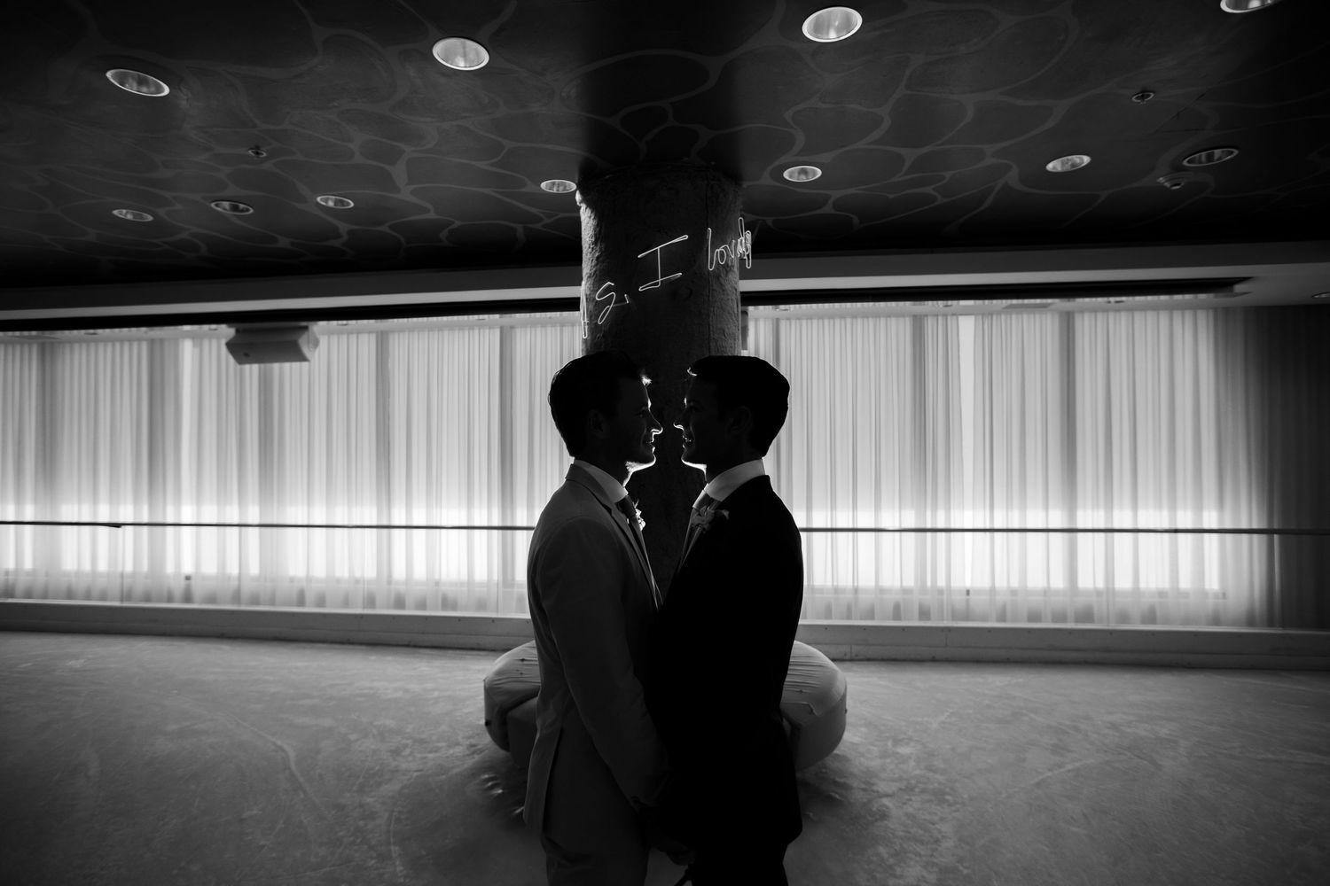 Artistic black and white silhouette shot in an indoor venue with dramatic lighting.