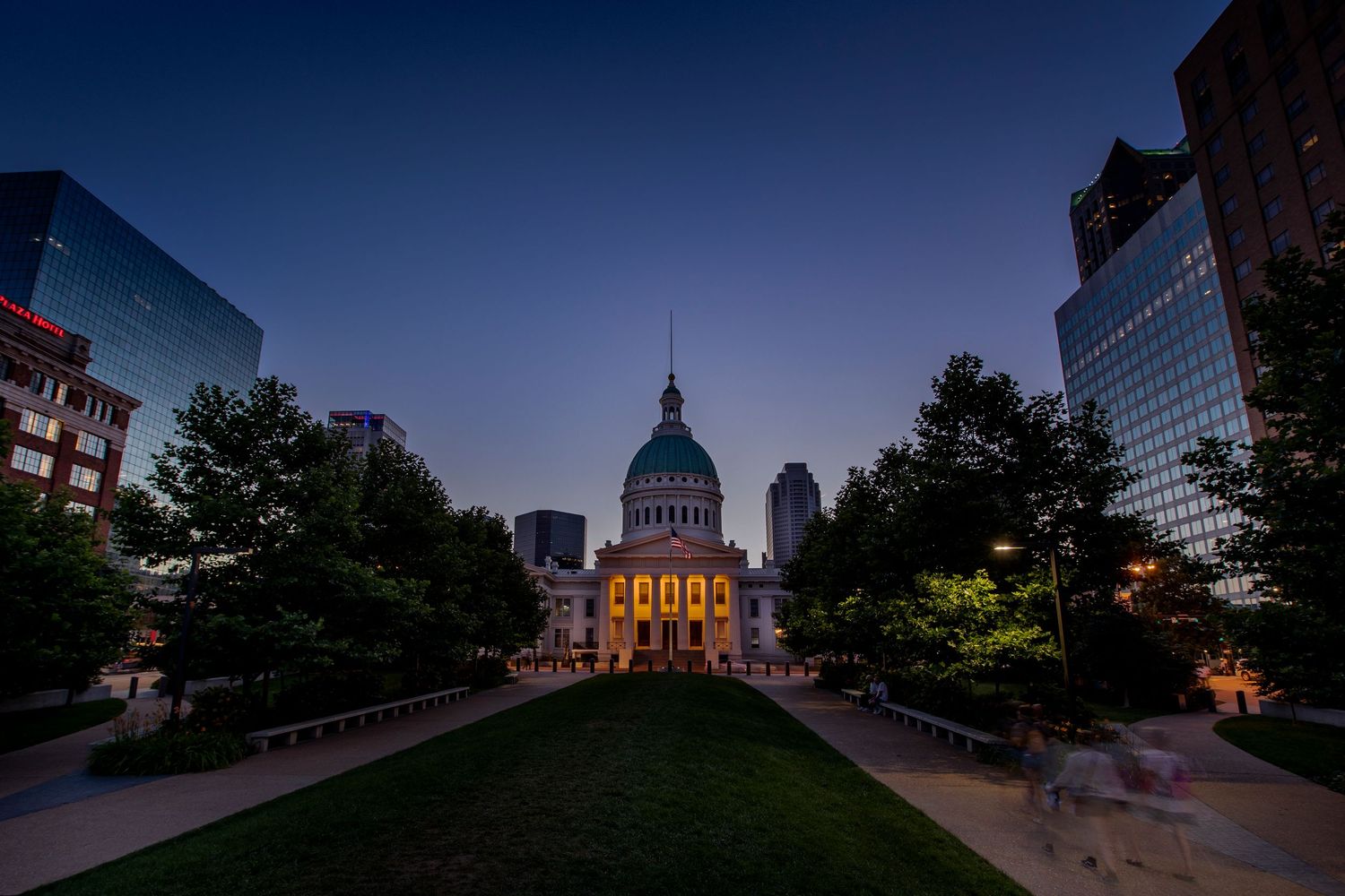 Panoramic dusk cityscape of Indianapolis showcasing the illuminated State Capitol dome and modern skyscrapers.