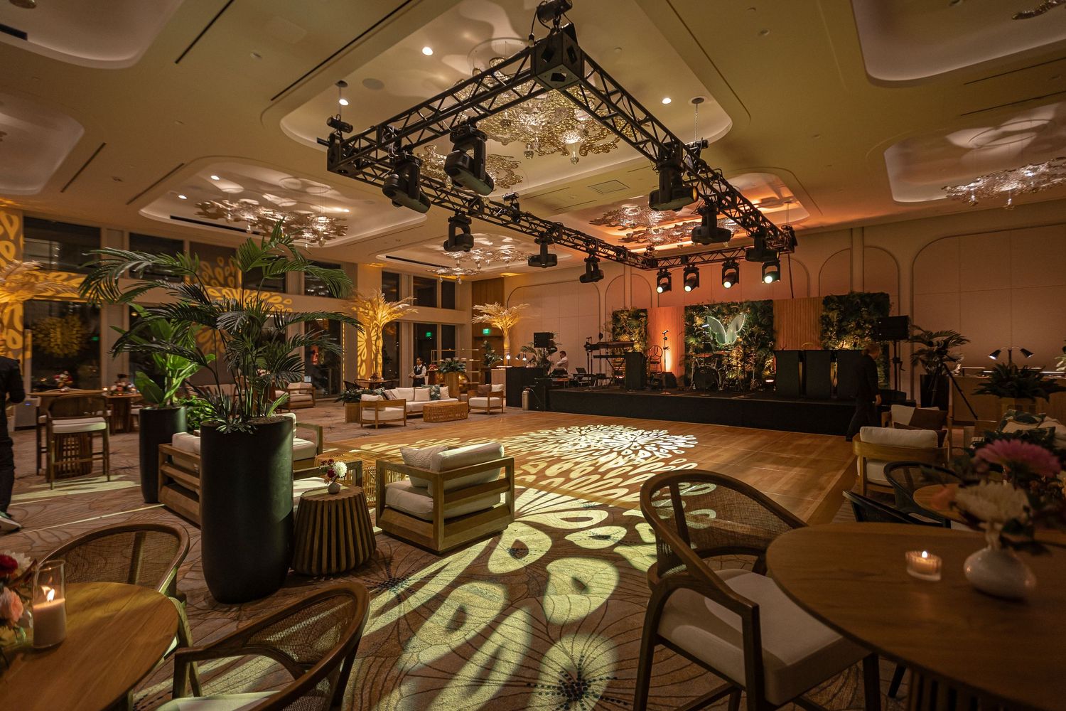 Modern event venue interior features exposed ceiling, stage lighting, and sleek wooden flooring for performances.
