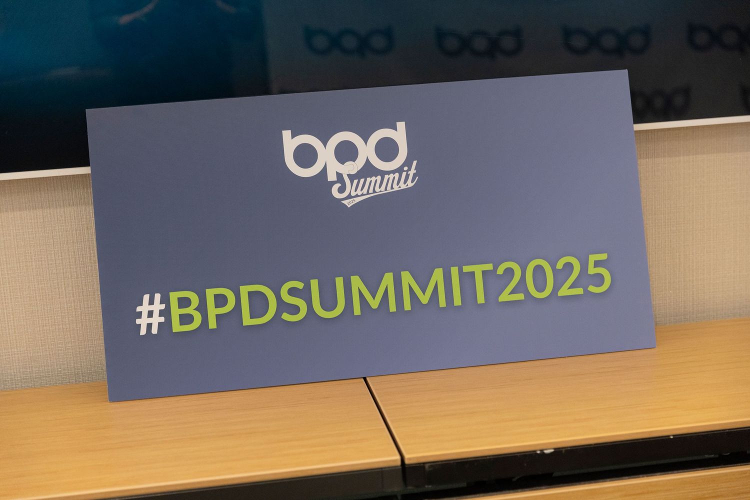Conference stage setup with BPD Summit 2025 hashtag displayed in professional event branding and lighting.