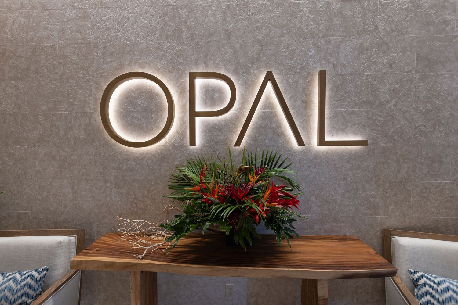 Modern conference space with white seating and wood accent wall decorated with holiday greenery.
