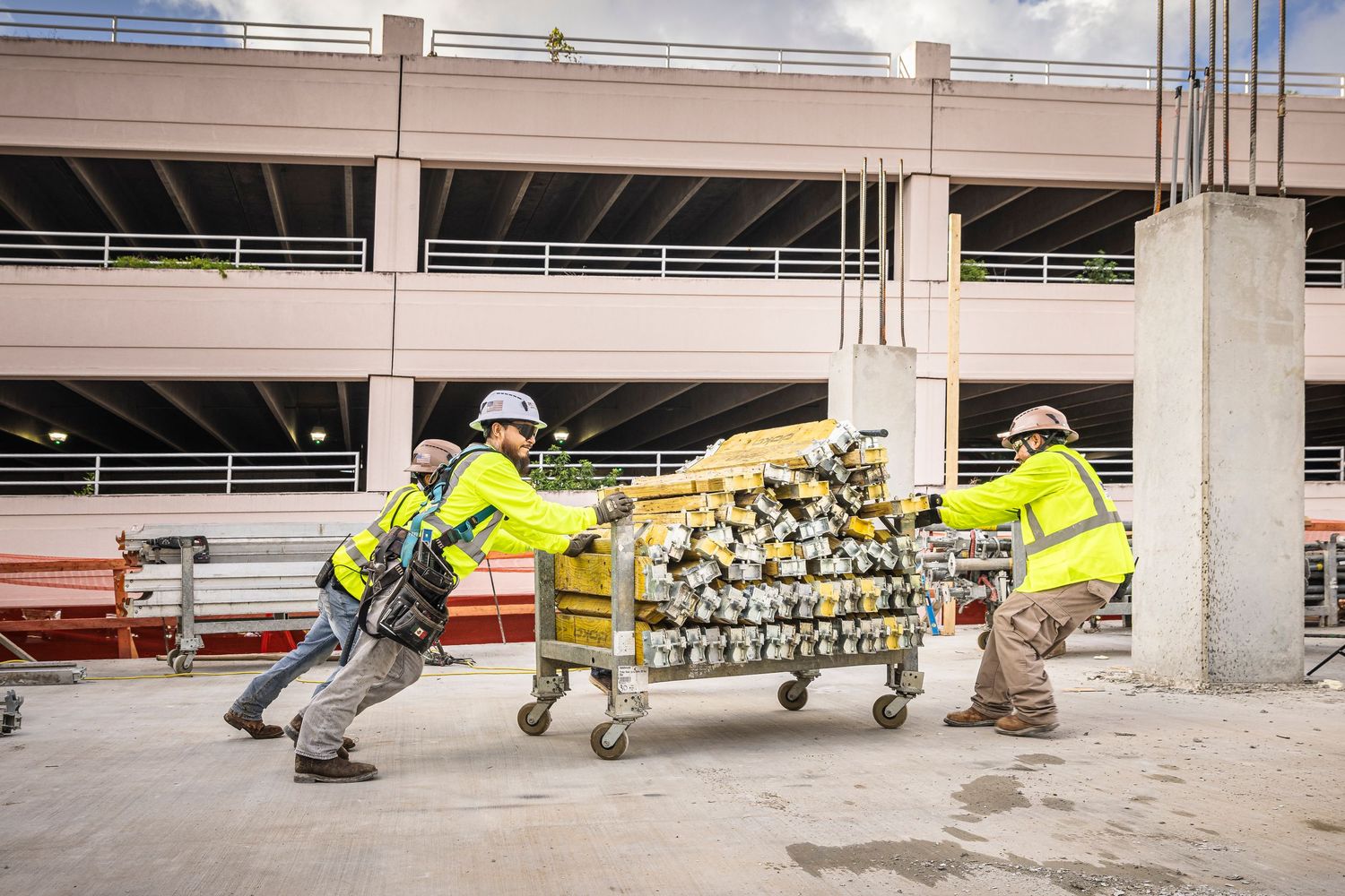 Emergency responders in high-visibility gear demonstrate rescue techniques in a concrete structure.