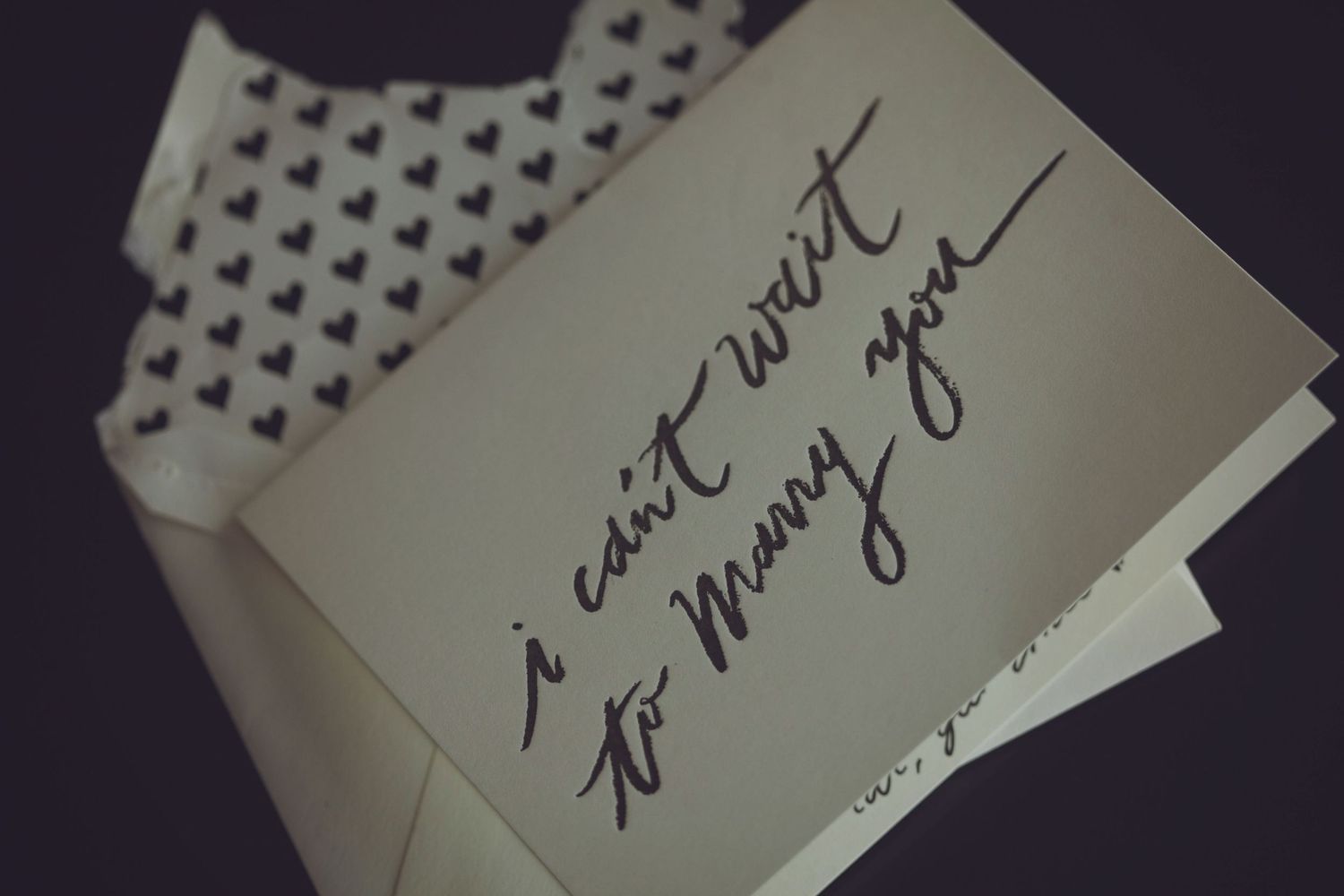 Close-up of handwritten text on white paper with heart pattern border.