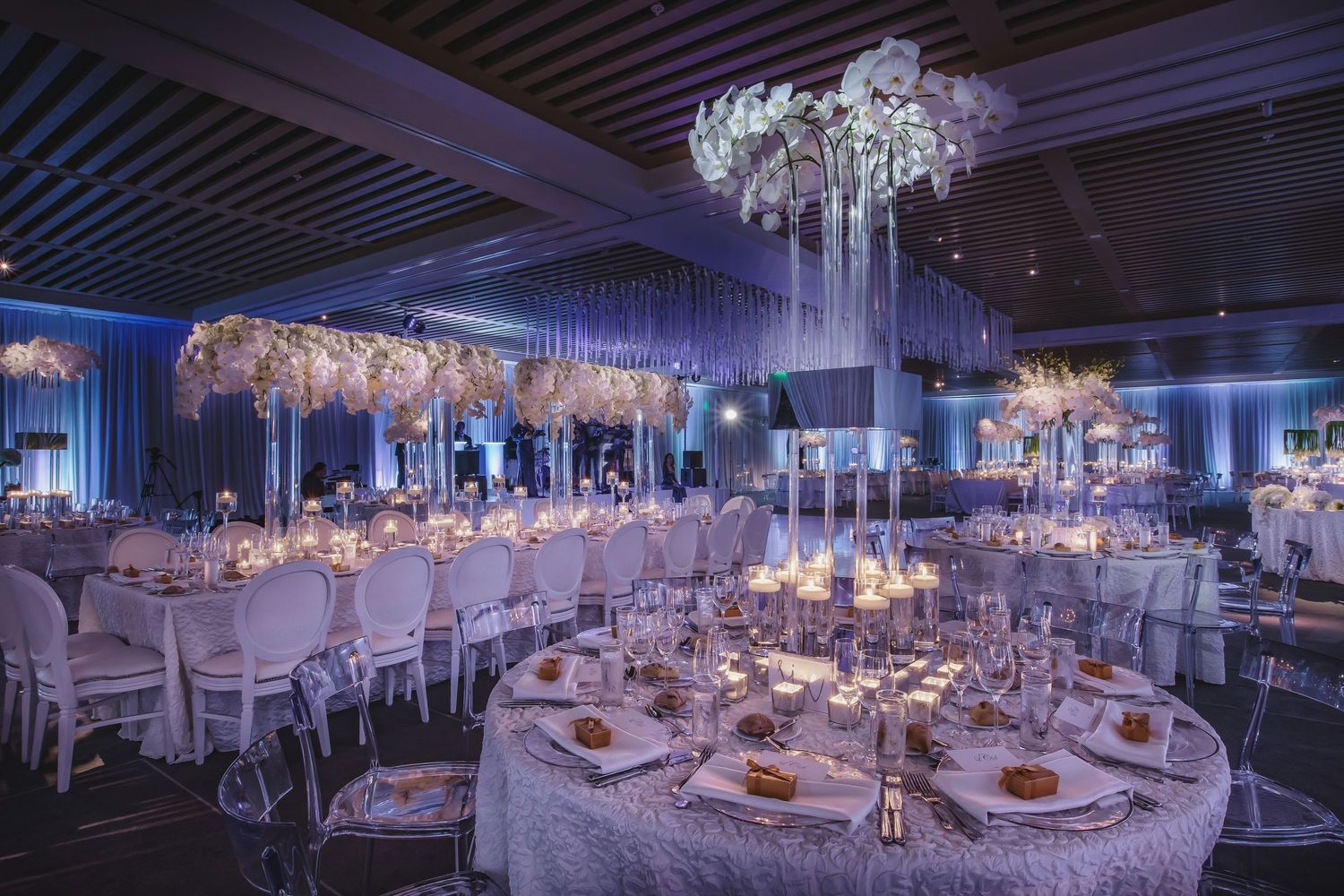 Luxurious banquet hall decorated with crystal chandeliers and white linens.