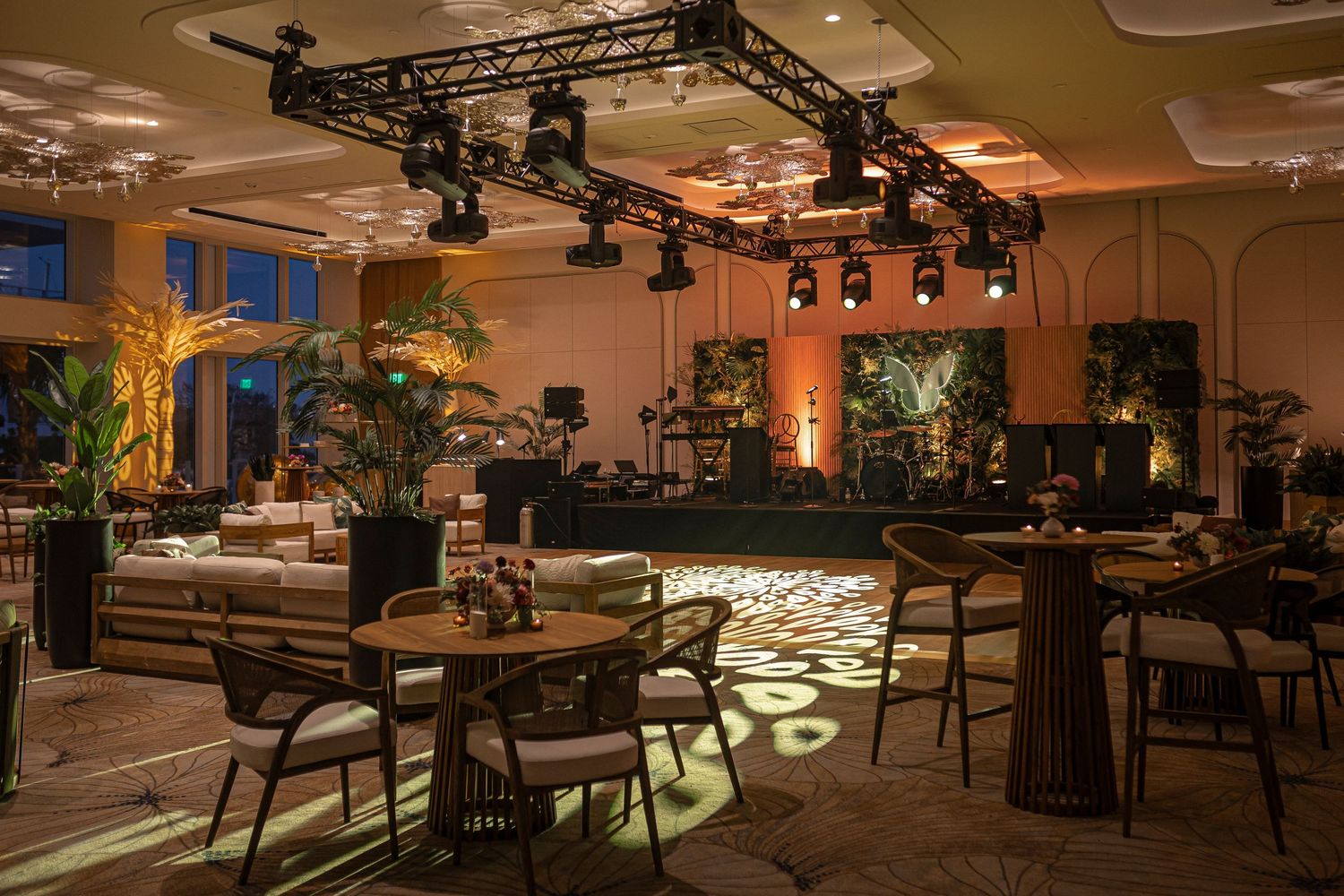 Luxury restaurant interior with mood lighting features elegant dining tables and modern lighting fixtures mounted on exposed rafters.