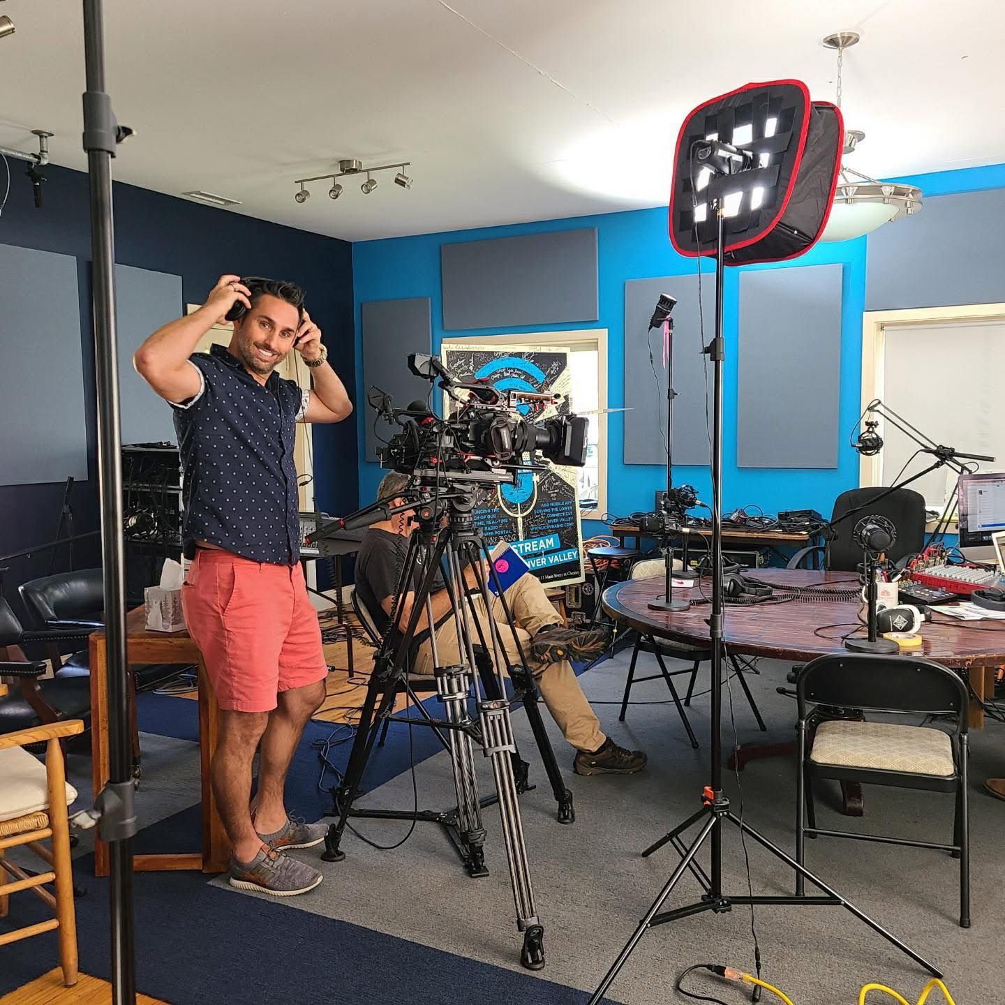 Professional video production setup in a studio with cameras, lighting equipment, and recording gear arranged for filming.