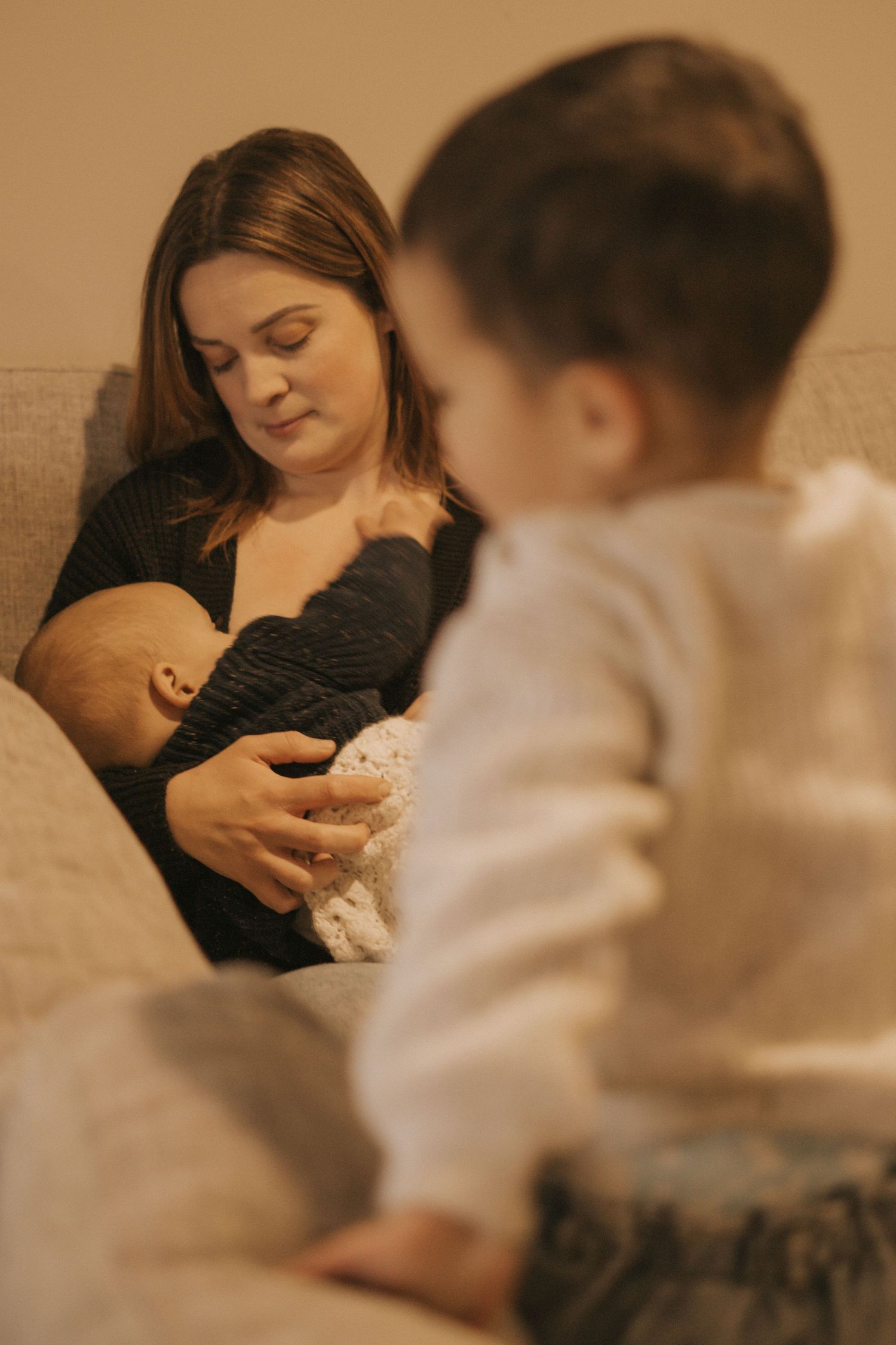 Warm-toned photos capturing intimate bonding moments between parent and young child on a couch.