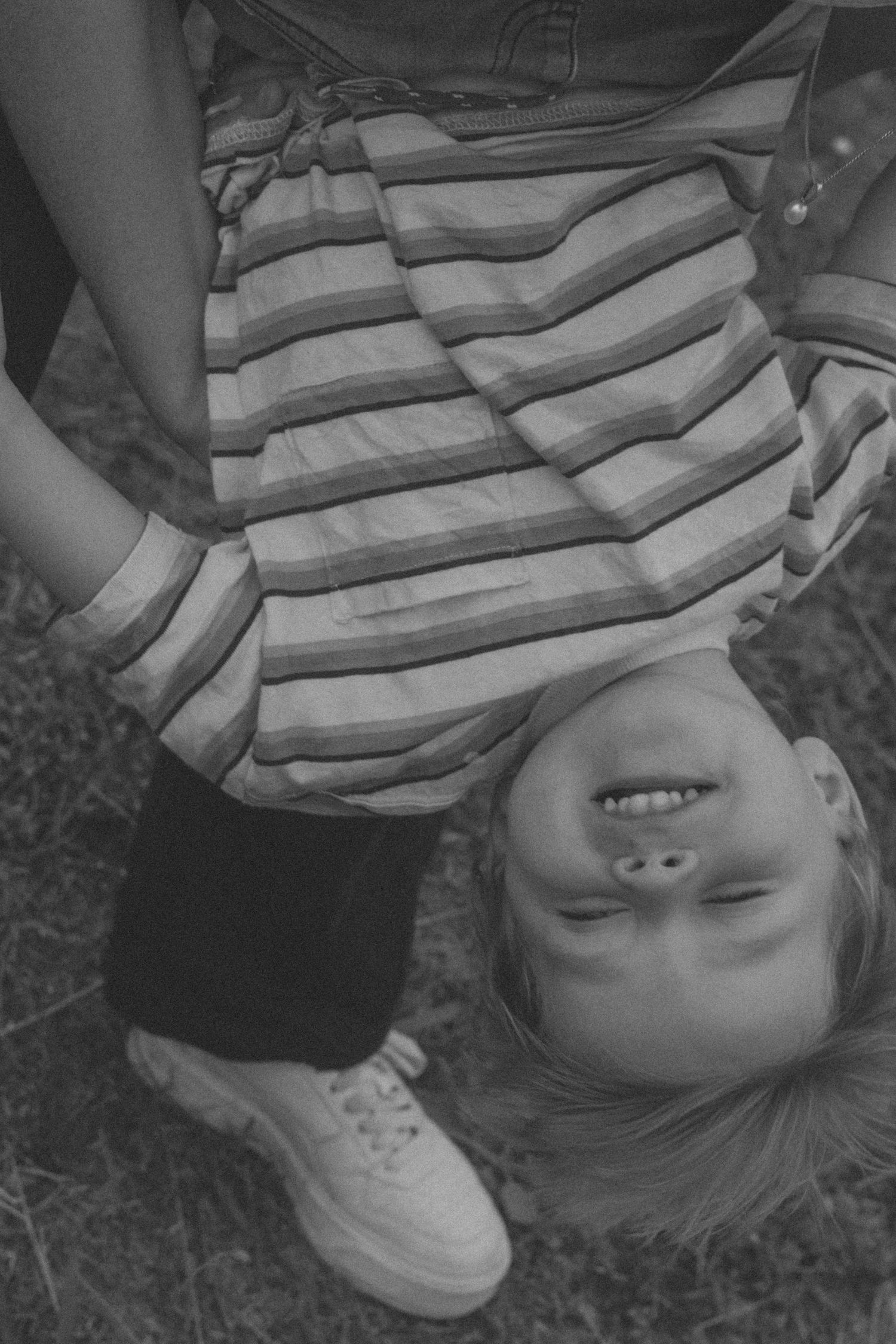 A black and white photo series shows a person lying down and playfully turning their head in different positions.