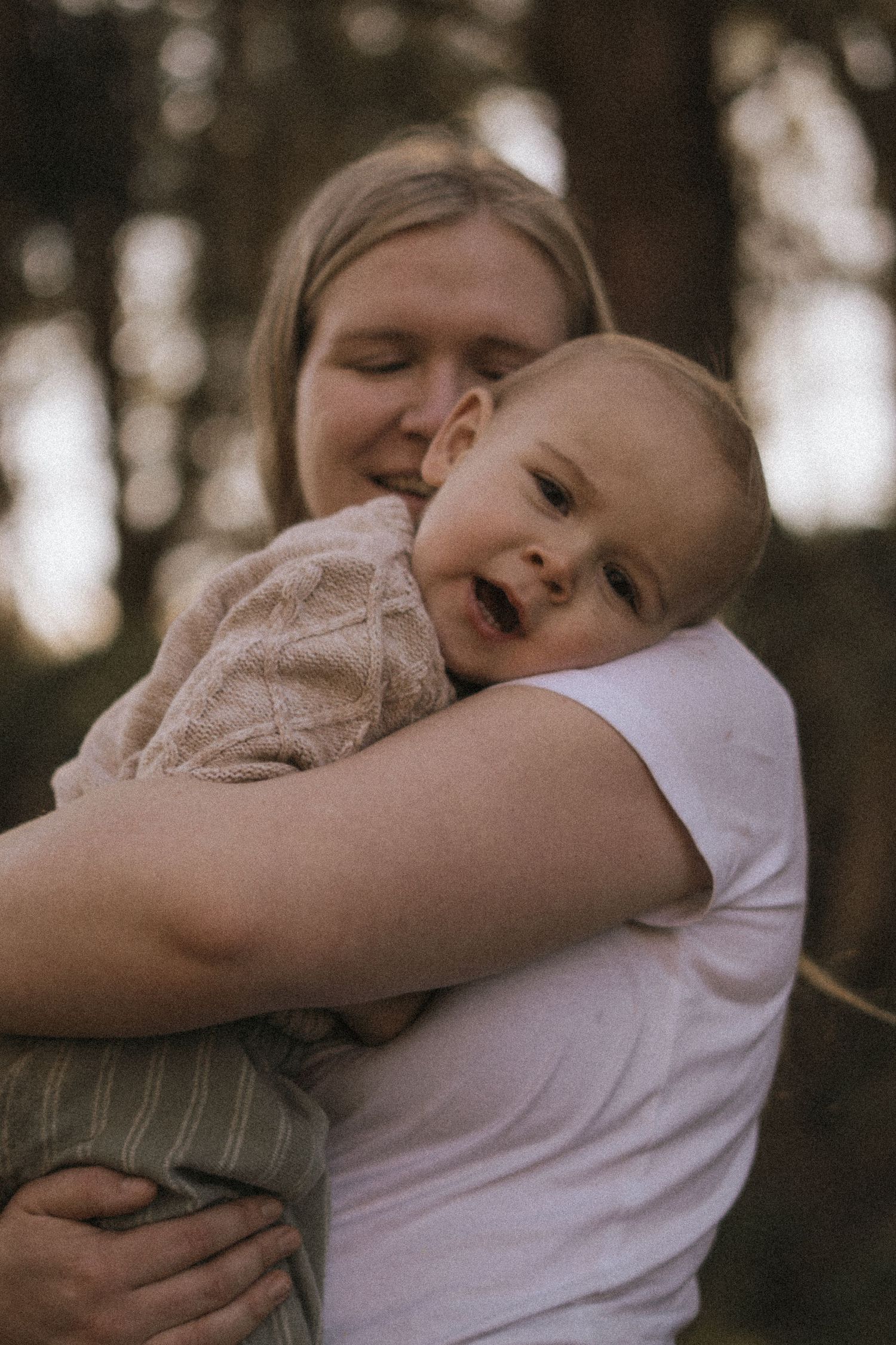 Tender embrace between parent and child captured in warm sepia tones.