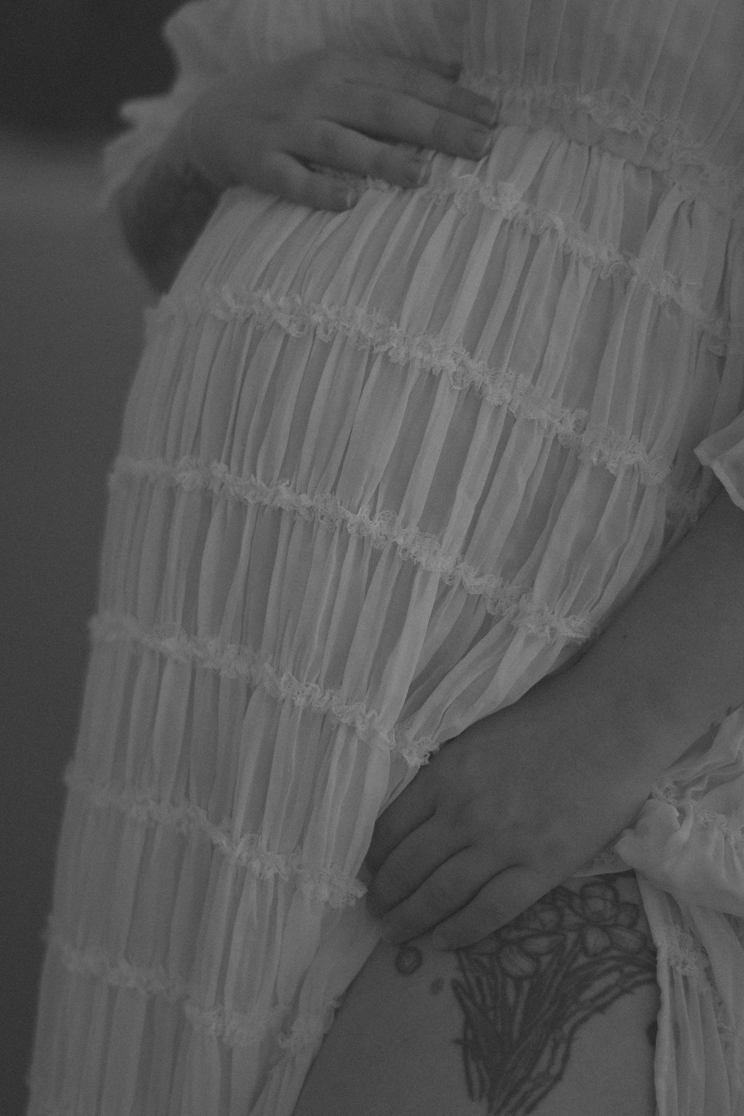 Close-up view of delicate white ruffled fabric details showing intricate layers and textures.