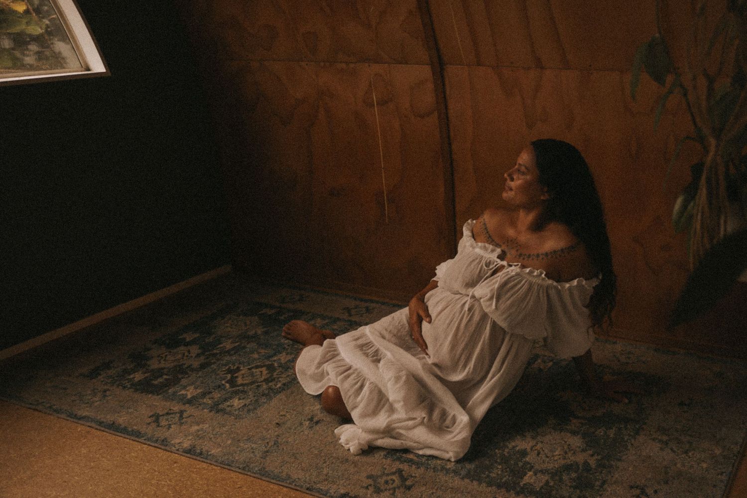 Intimate indoor portrait session with soft lighting and rustic backdrop.