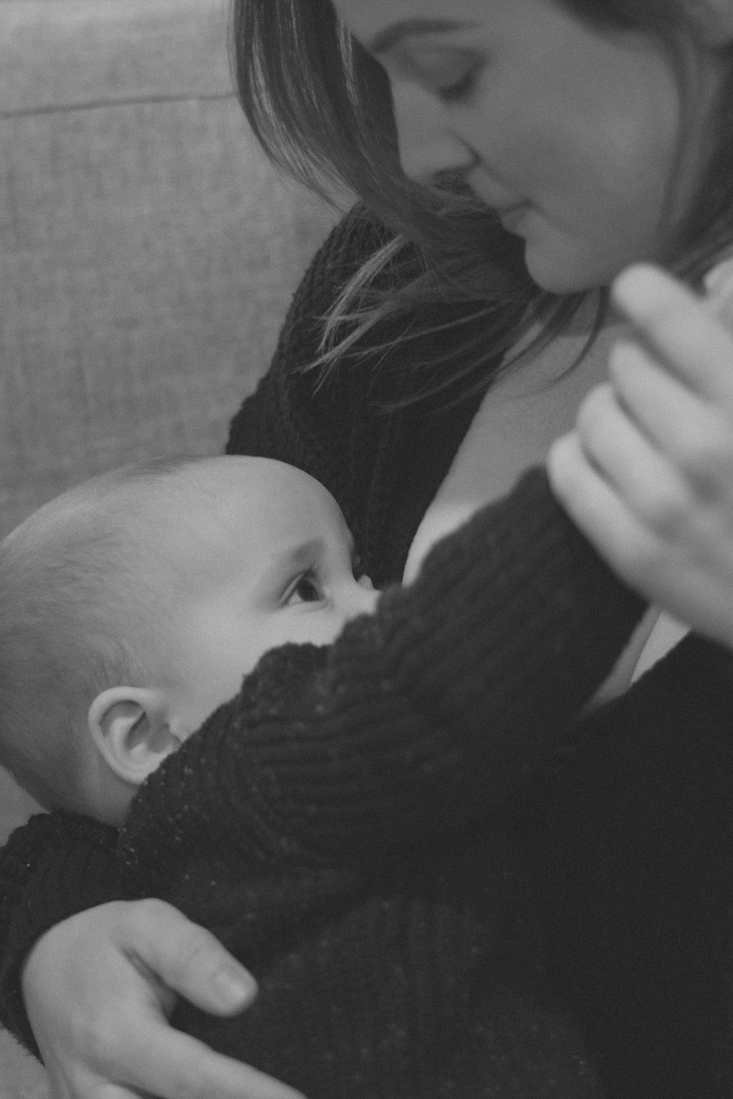 Black and white intimate portrait of parent feeding baby.