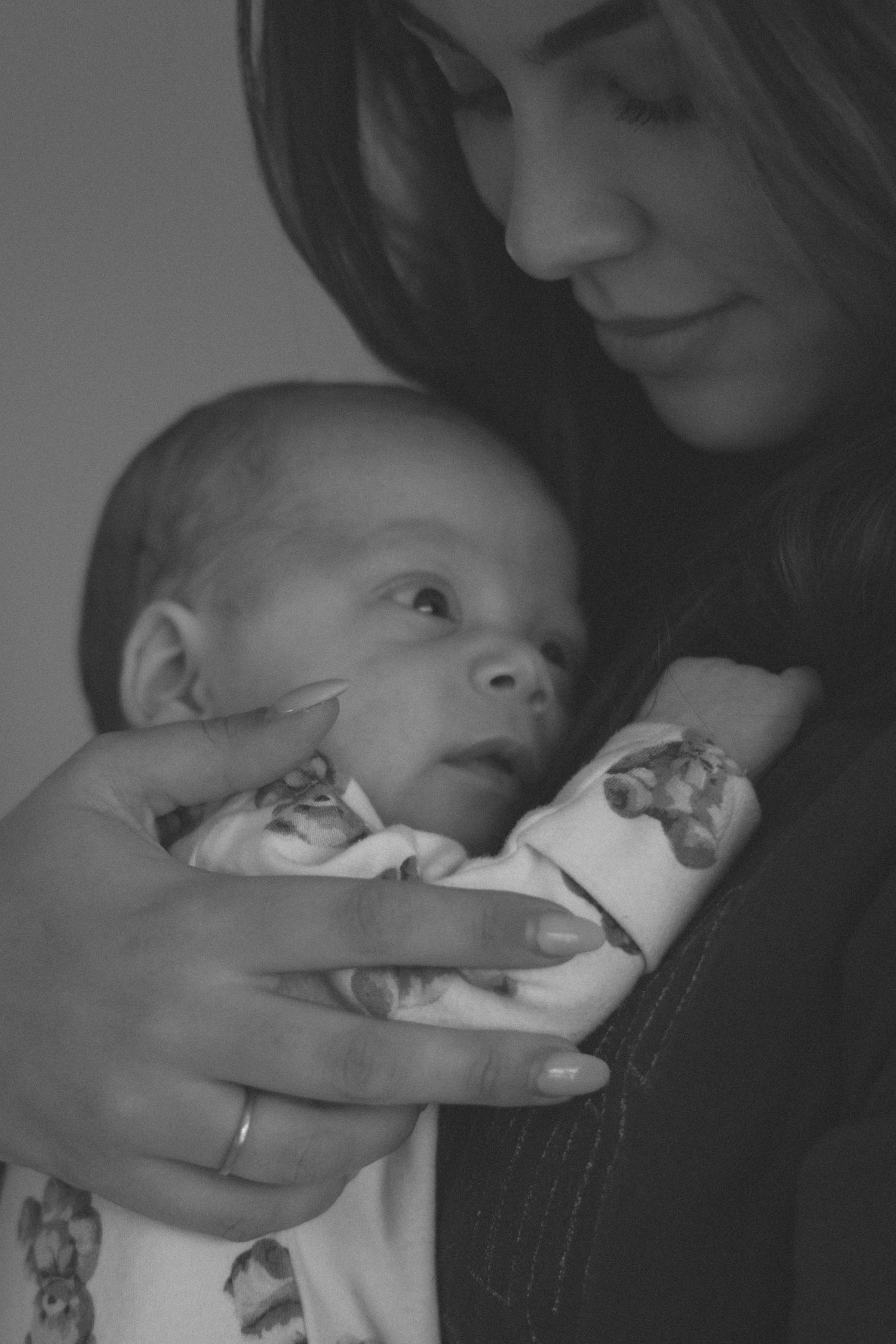 Black and white image of infant being cradled while sleeping.