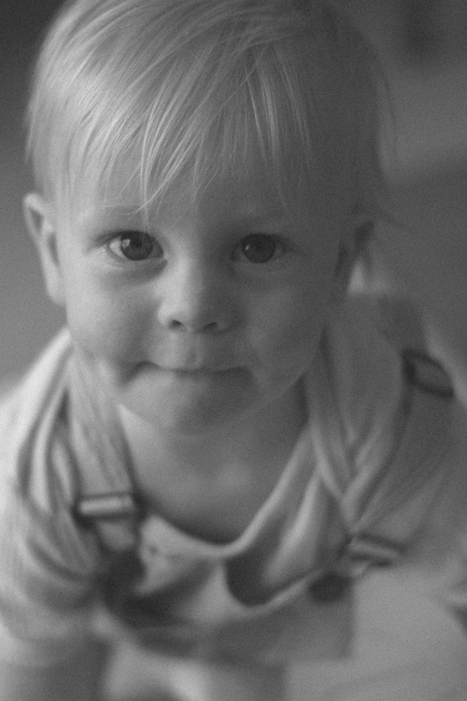 A series of black and white close-up photographs showing a child's changing expressions from neutral to joyful.