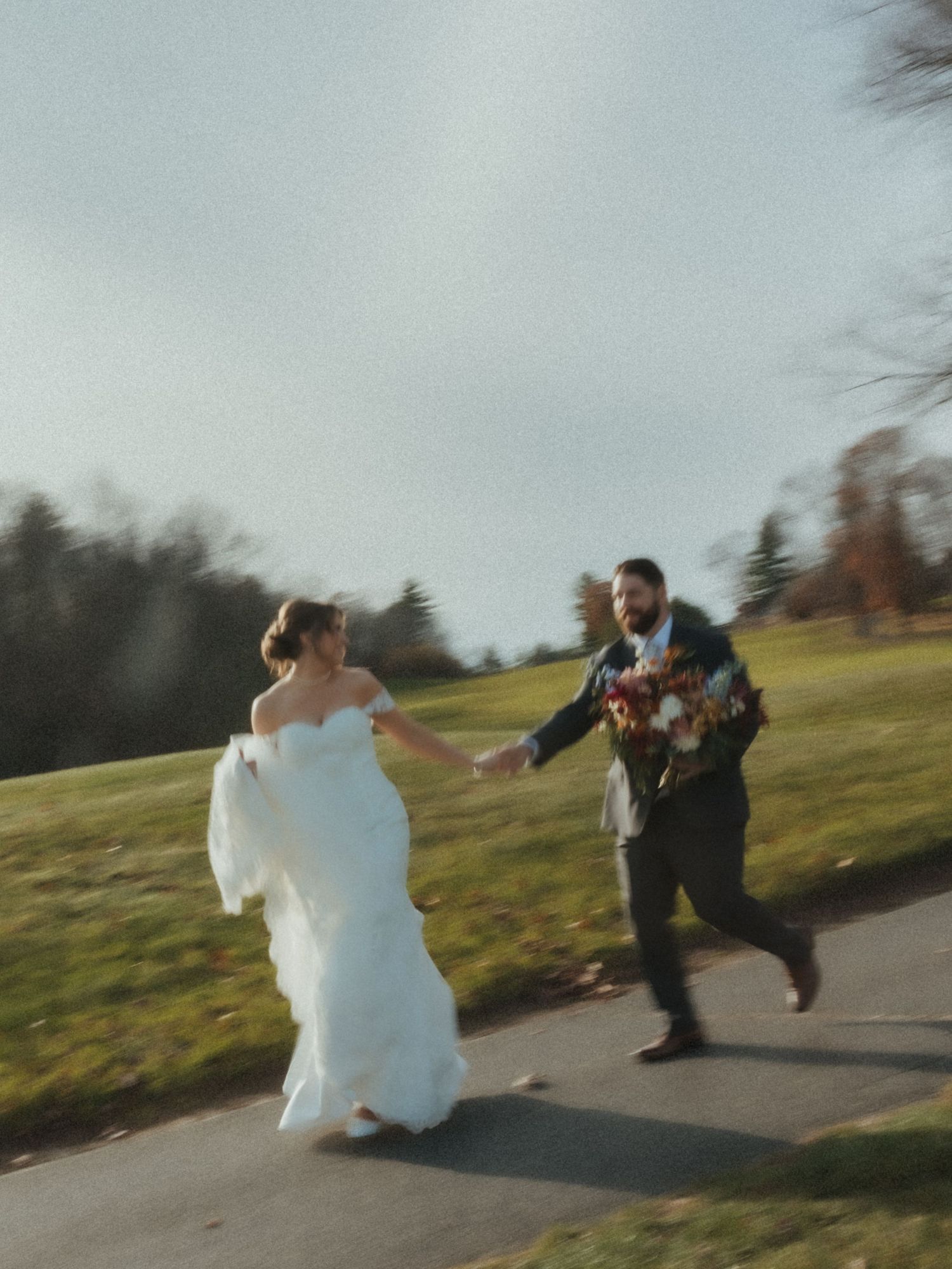 A sequence of four action shots showing a bride and groom playfully chasing each other on a paved path outdoors.