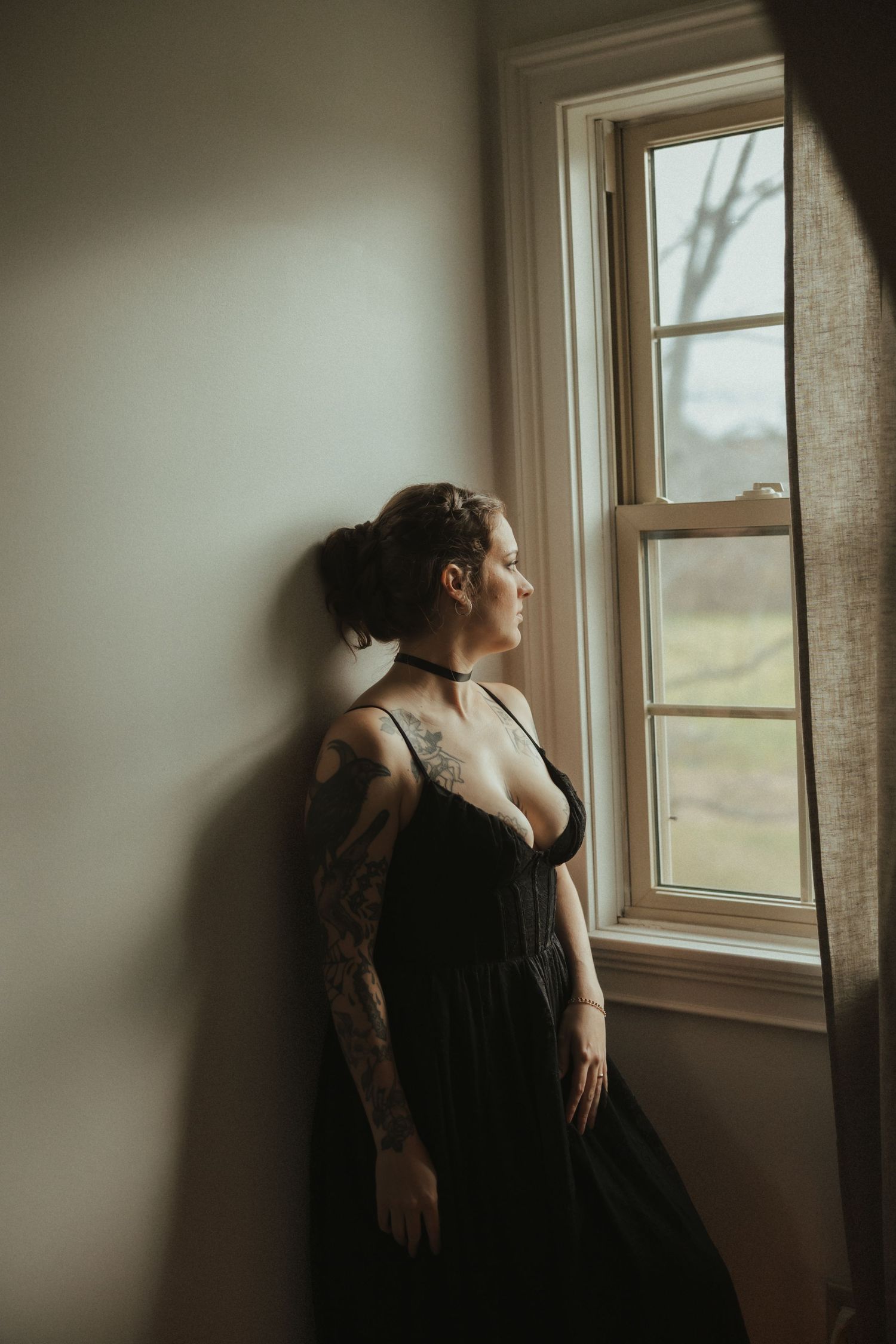 Atmospheric boudoir photos showing silhouette against window light in a minimal room.
