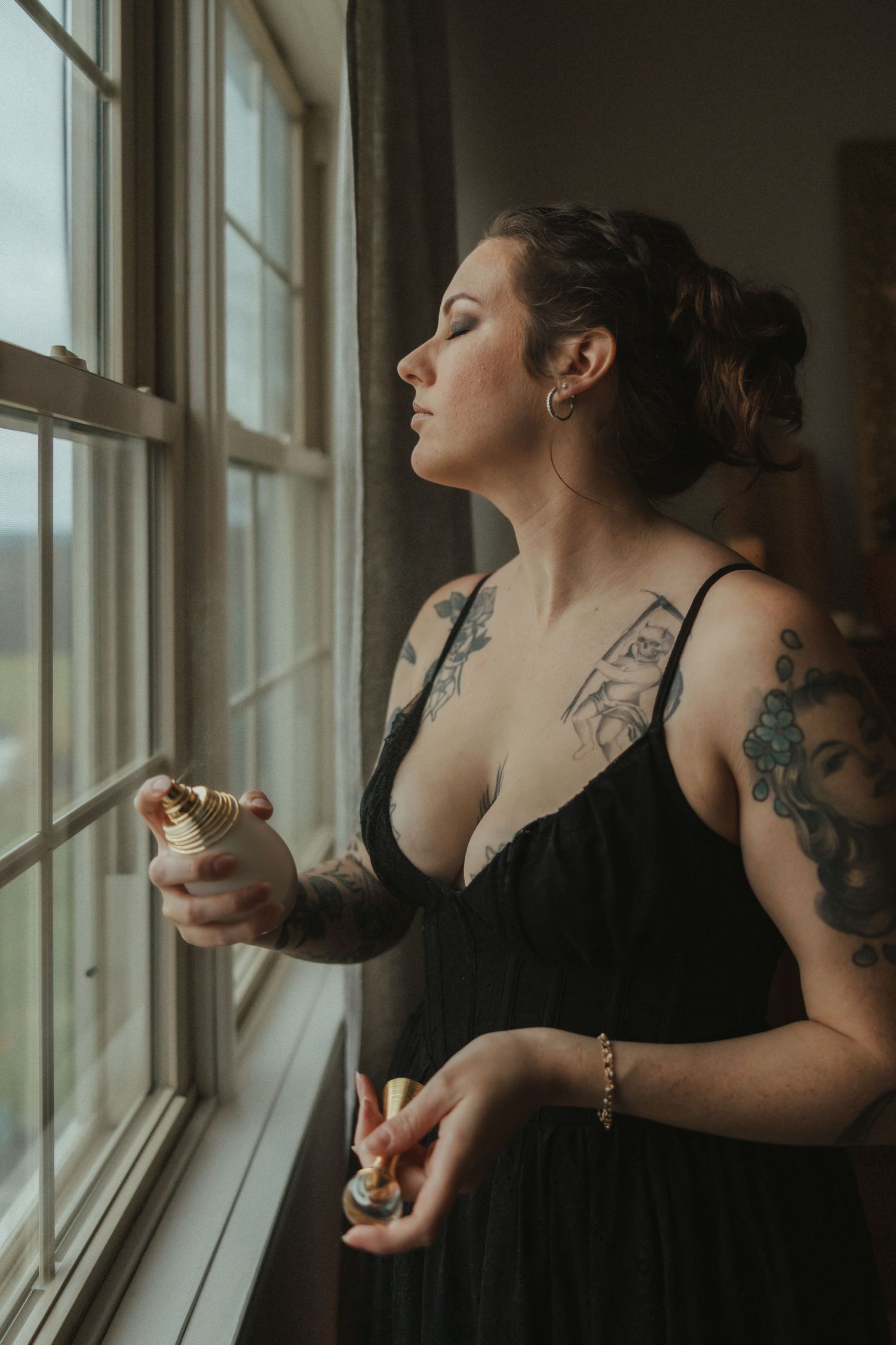 Artistic sequence showing a figure in black dress with tattoos near a bright window.