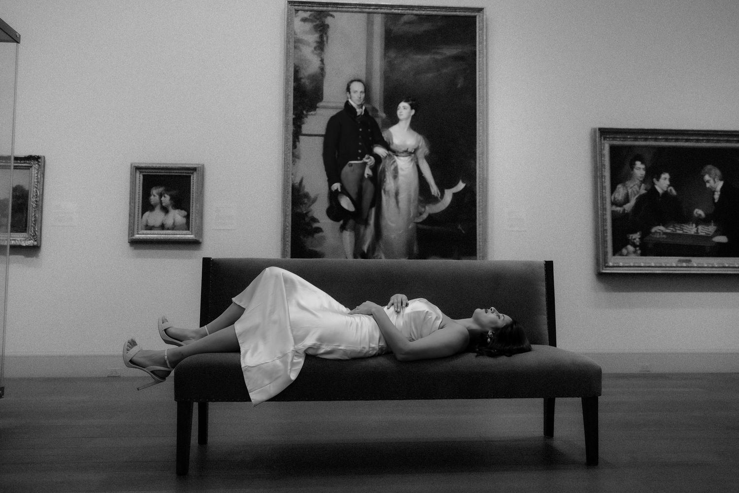 A series of black and white photographs displayed in a gallery showing various artistic compositions and scenes.