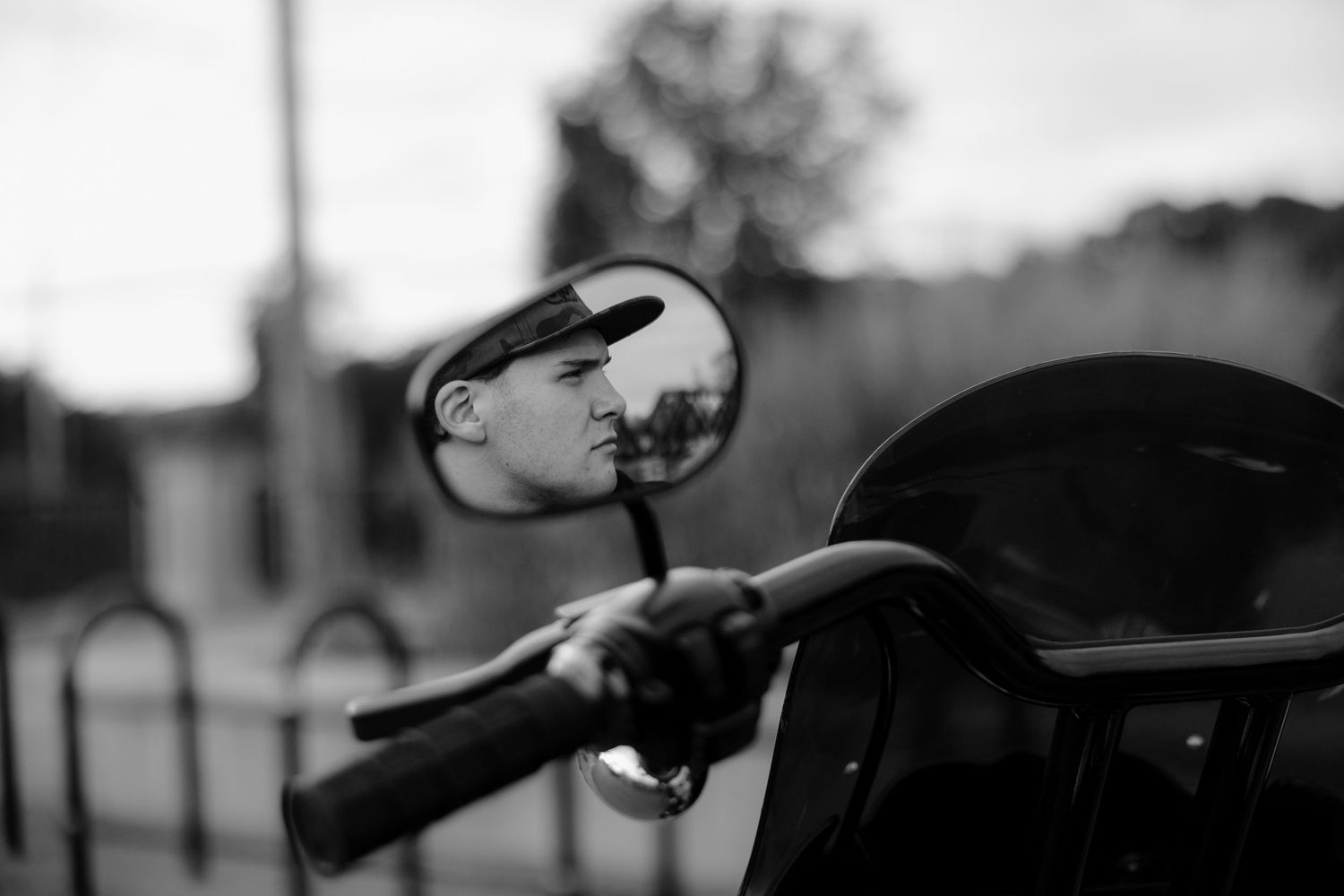 Black and white photograph of a person riding a motorcycle through a turn on a racetrack.