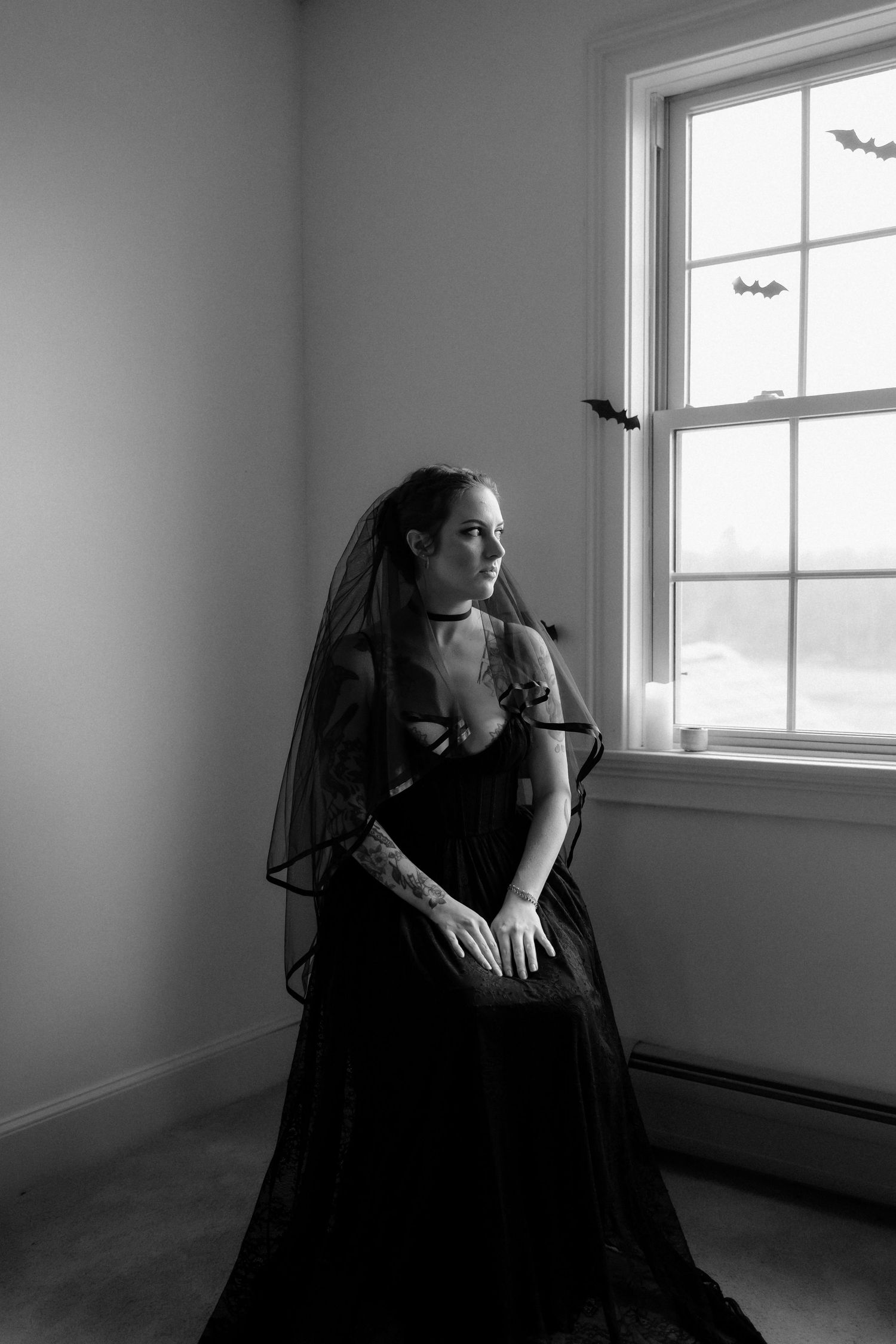 A dramatic black and white series showing a figure in dark clothing by a bright window in an empty room.