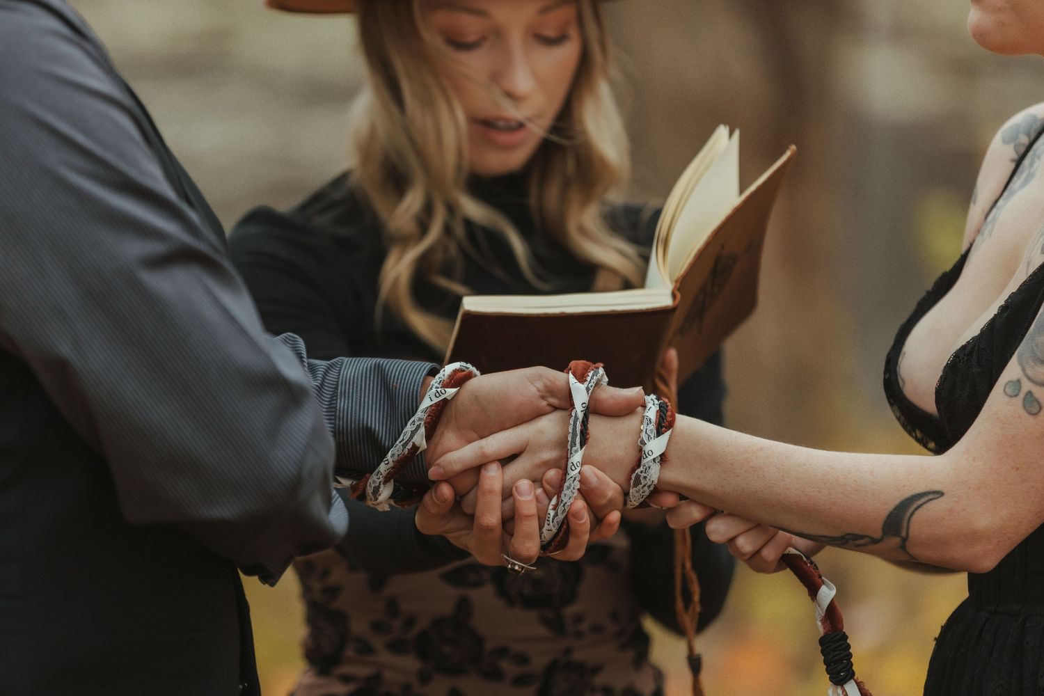 Hands exchanging wedding rings during an intimate ceremony in warm lighting.