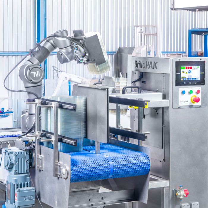 Photography of Brillopak robotic arms in a food packaging and manufacturing plant.