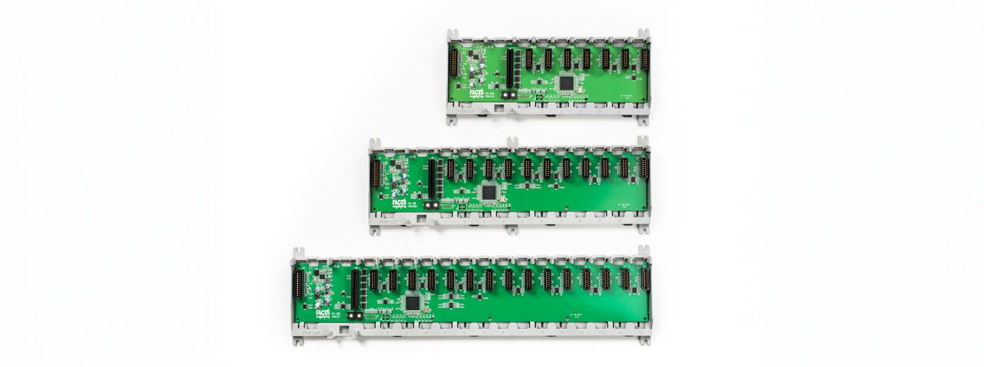Three green circuit boards of increasing length with electrical components and connectors mounted on them.