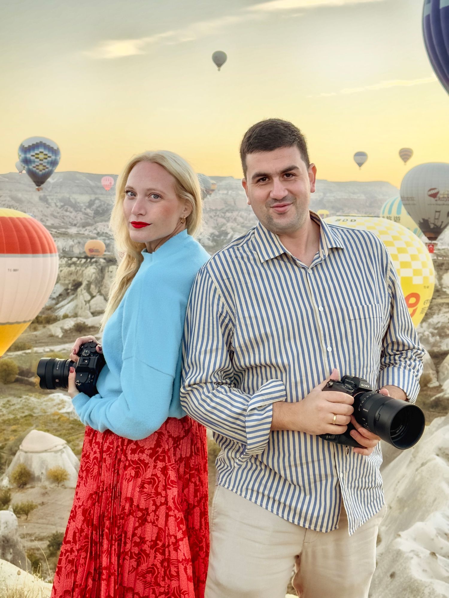 Hot air balloons floating in background of photography session in Cappadocia landscape.