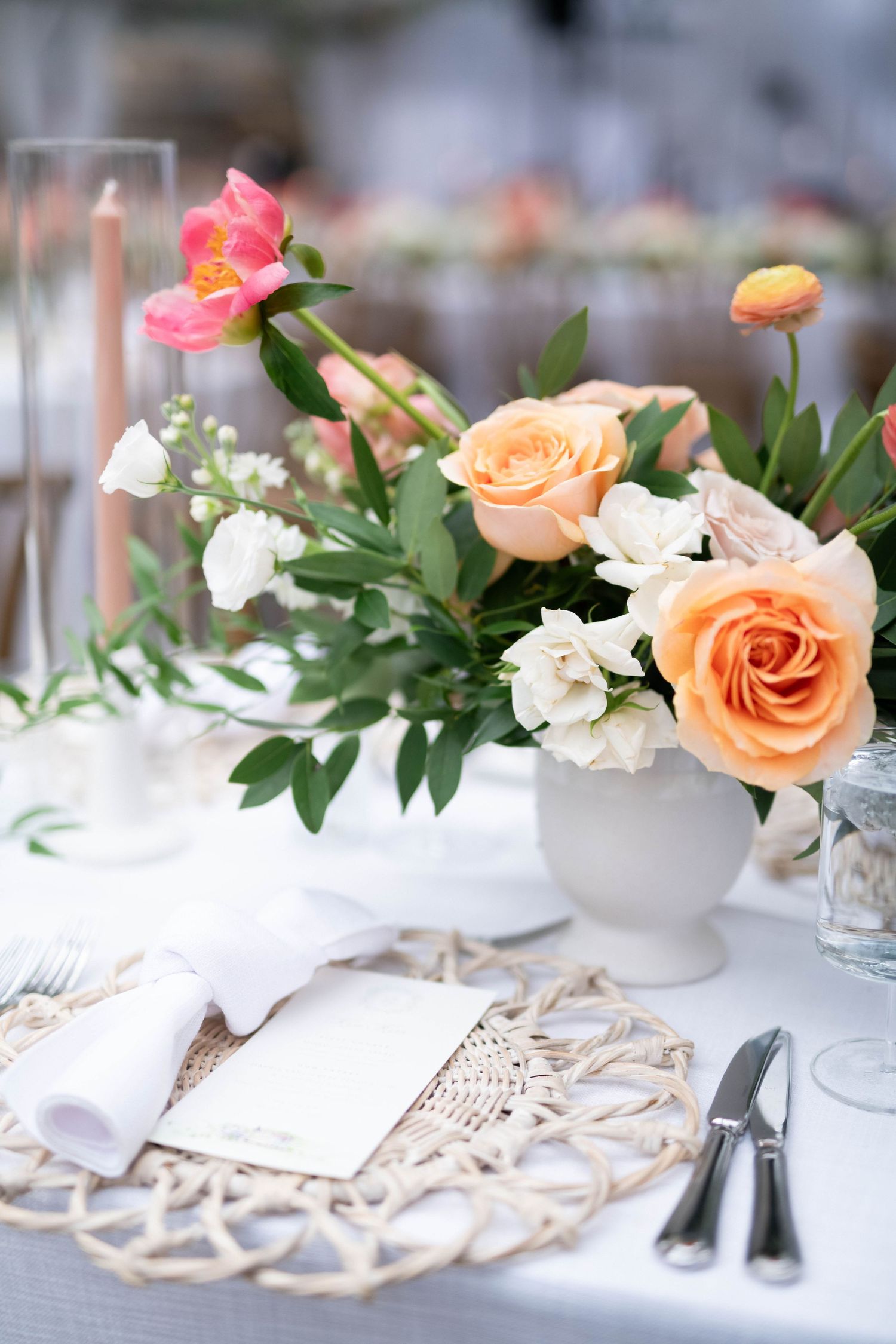 Elegant table settings with peach and pink roses arranged on delicate lace runners.