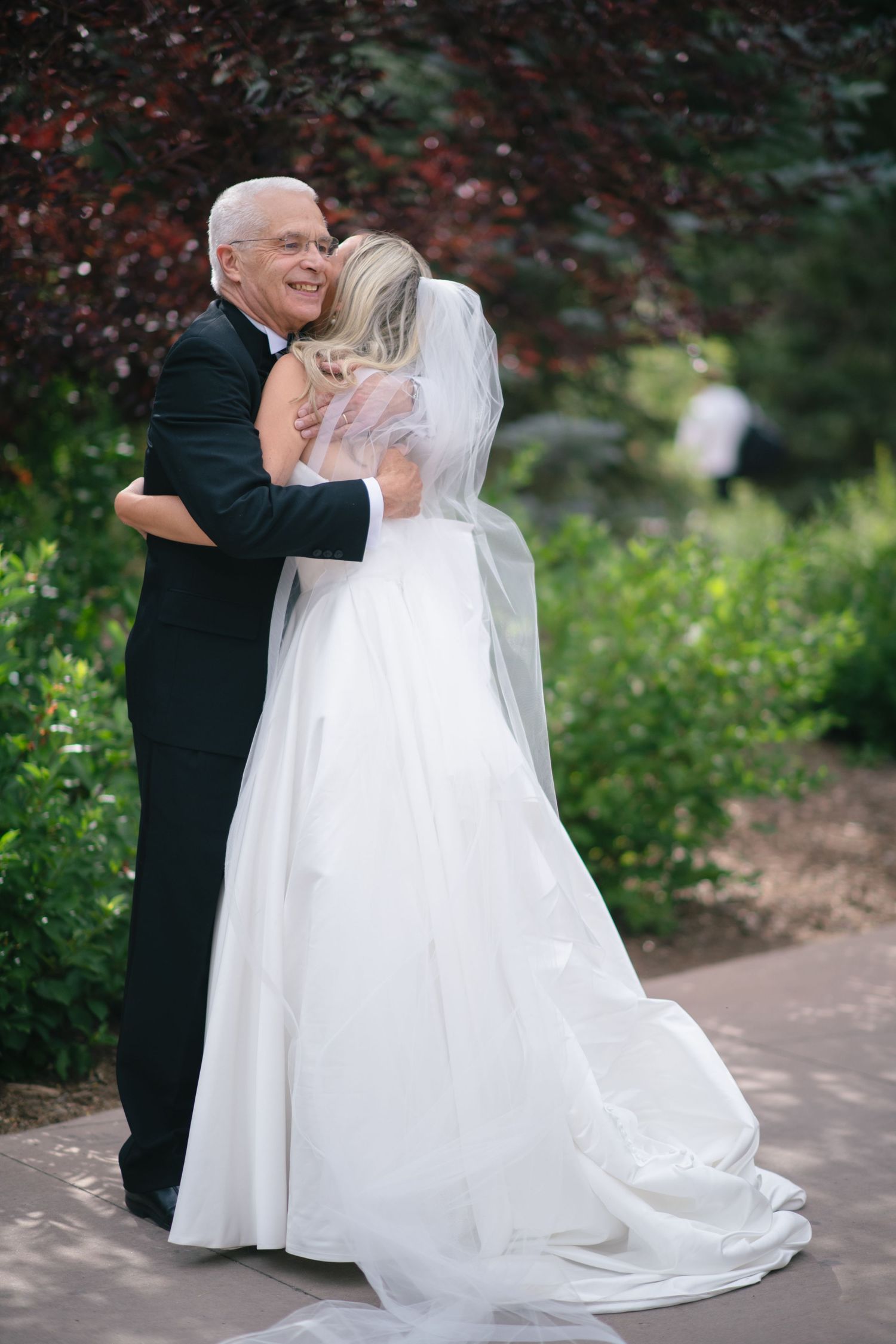 A romantic wedding dance moment captured on a garden path.
