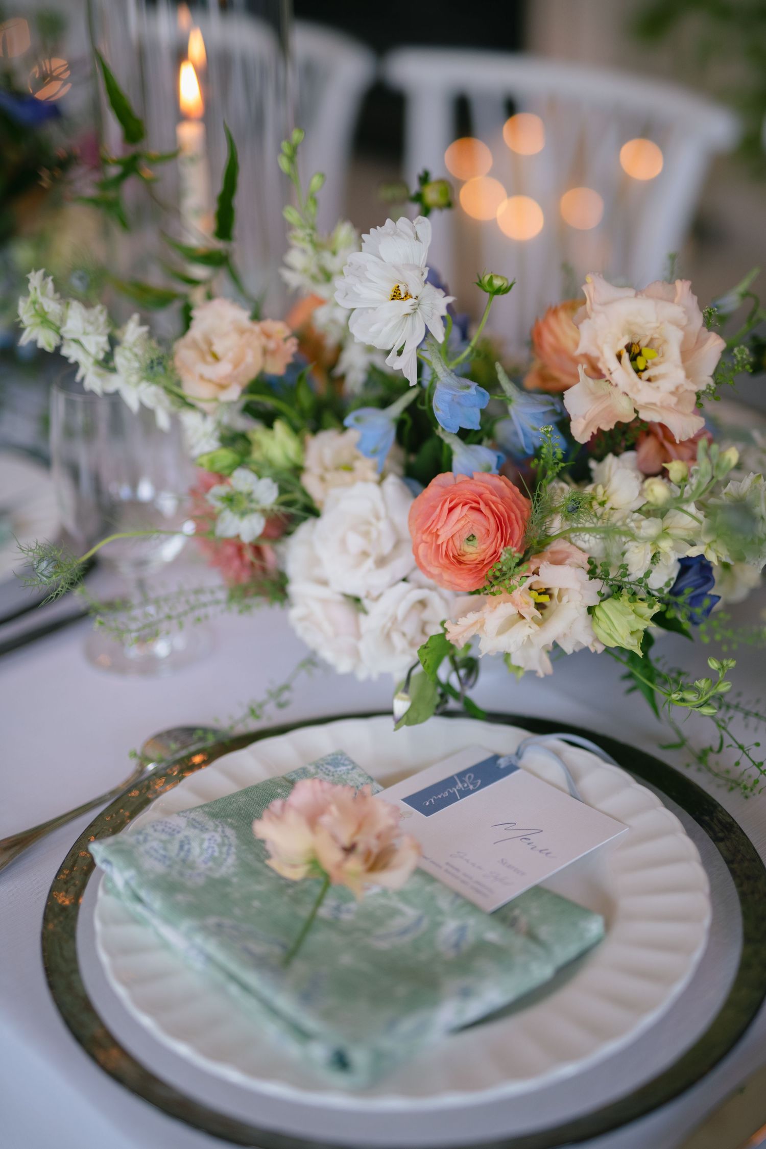 Wedding table place settings with delicate floral arrangements and mint green accents.