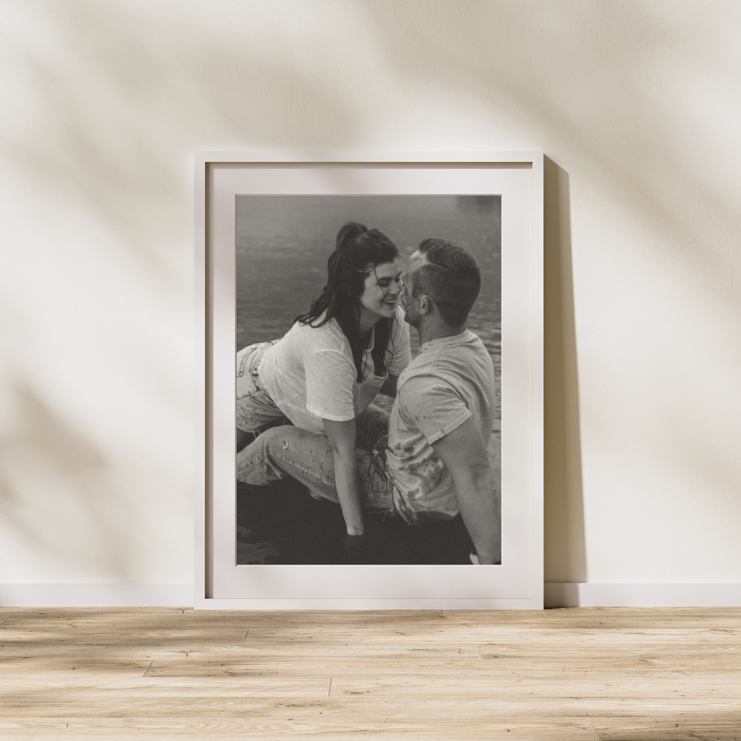 A series of black and white framed photographs displayed in a row on a light colored surface.