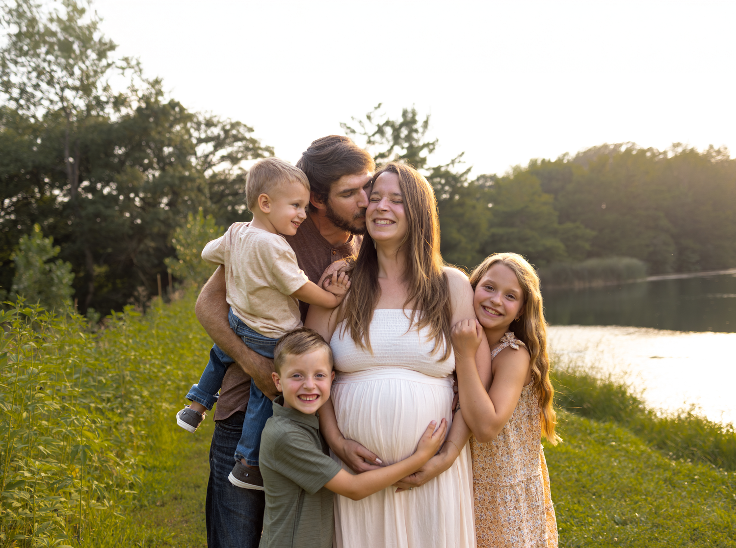 A group of people share joyful moments together in a sunlit field of yellow wildflowers at golden hour.