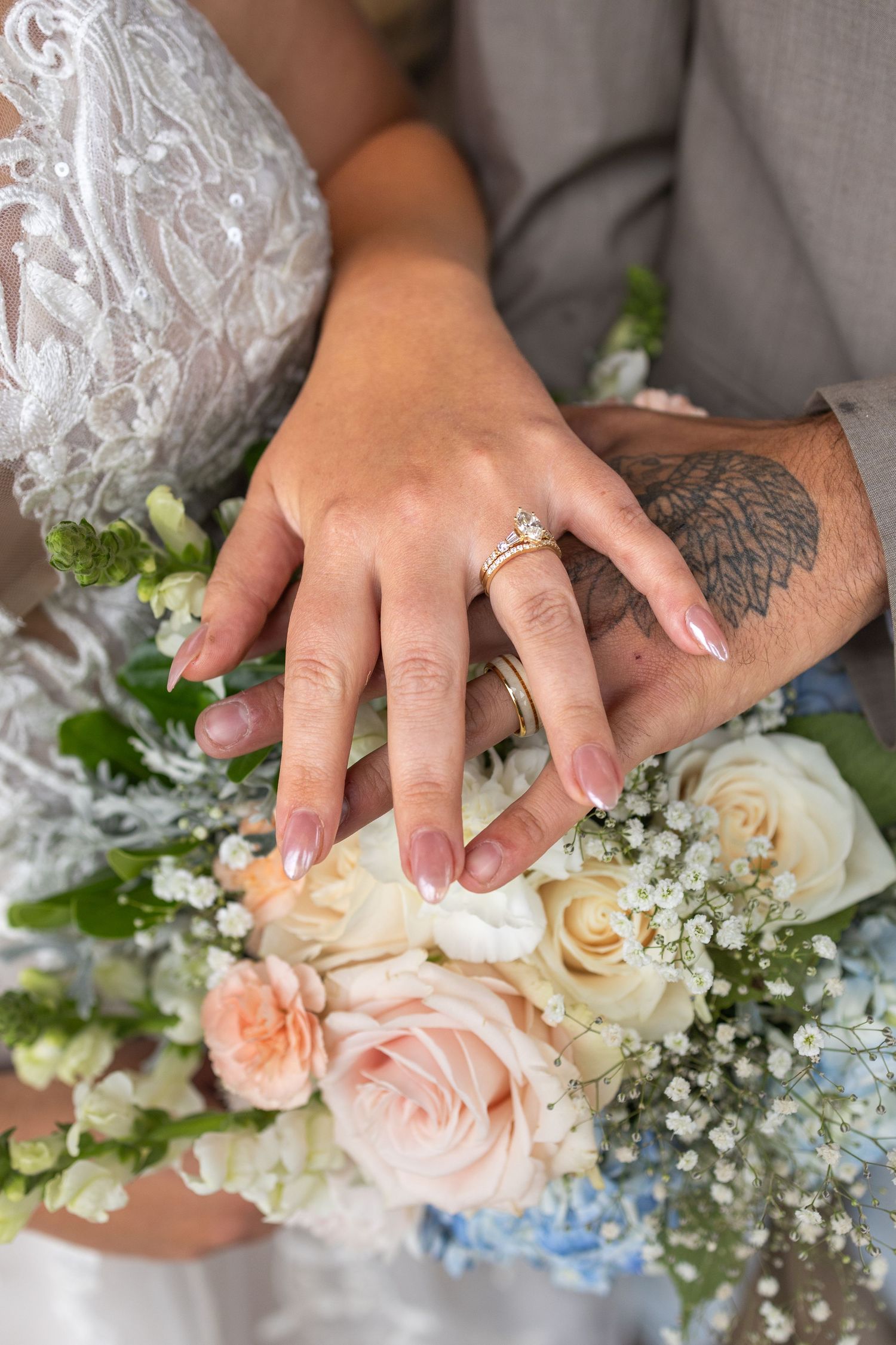 Close-up series of hands with wedding rings resting on a delicate bouquet of pink roses, white flowers, and baby's breath.
