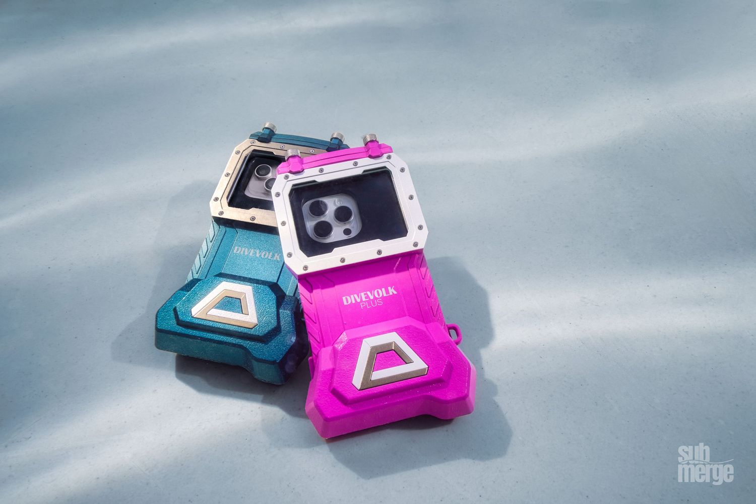 Pink and blue vintage LCD gaming consoles cast shadows against a light background in a nostalgic still life.