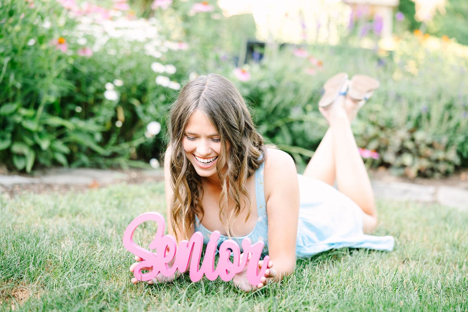 A green garden setting with pink dress and blur effect creates a dreamy summer photoshoot atmosphere.