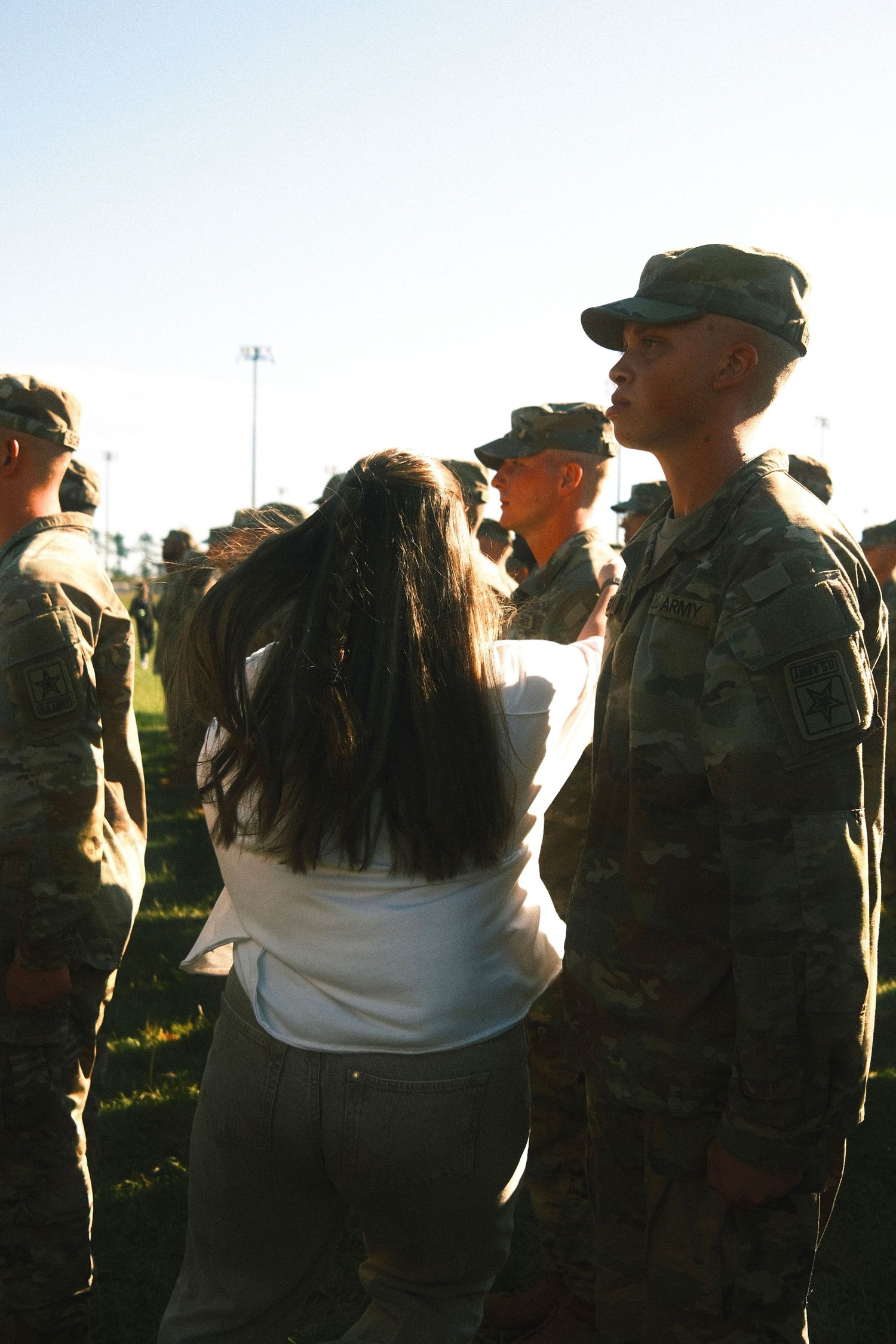 A group of military personnel, including both men and women, standing together in a field.